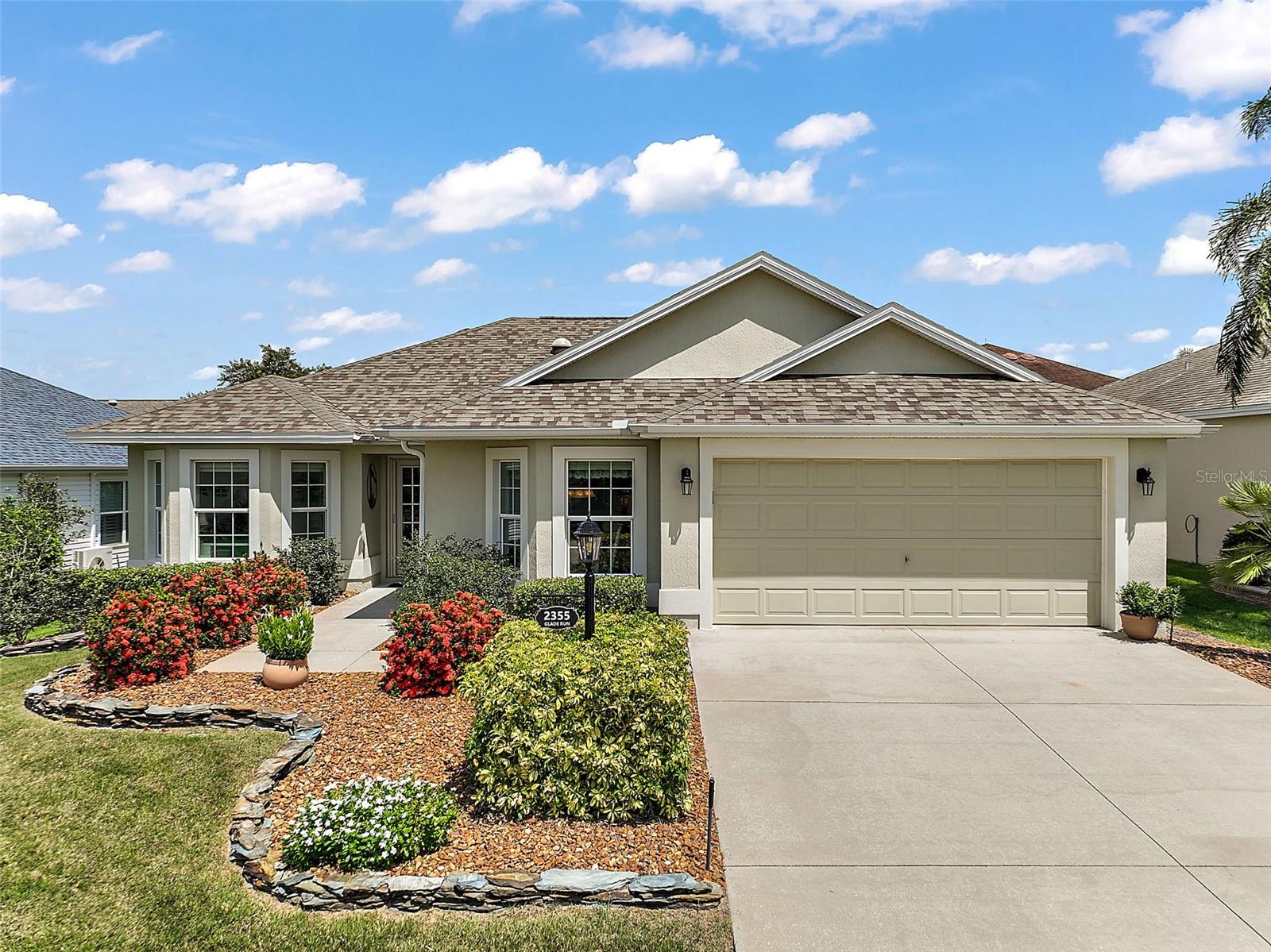 MOVE-IN READY AND PACKED WITH UPGRADES! Welcome to this beautifully maintained Designer Jasmine model—a Concrete Block & Stucco 3/2 with a large 2-car garage, PRIVACY and GLASS ENCLOSED LANAI featuring a mini-split HVAC system for year-round comfort and added living space! Major Updates Include: NEW ROOF (2023) with dual solar attic fans; NEW HVAC (2025); NEW Water Heater & Whole-House Water Filtration (2024); NEW Irrigation Panel, Garage Door System & Clothes Dryer (2024); SECO Surge Protector & Solar Tubes (x3); Inside, enjoy high vaulted ceilings, CROWN molding, and hickory cabinetry in the kitchen, baths & INDOOR LAUNDRY ROOM. The kitchen features a pantry, pull-outs, under-cabinet lighting, tile backsplash, and a breakfast nook with chair rail detail. The front guest room doubles as a home office or hobby space with a built-in desk, storage cabinetry, and Murphy bed. Additional highlights include: updated flooring; wood cornices & Bali shades; "Race Deck" garage flooring & pull-down attic stairs; solar blinds in the lanai; gutters & downspouts; hideaway screen door & upgraded entry door, upgraded landscape along with field stone slate wall & More! Prime Location! Nestled between Lake Sumter Landing and Brownwood Paddock Square, close to Colony Plaza, Havana Country Club, and a variety of recreation, shopping, and dining options. Don’t miss this one—it’s the whole package of comfort, style, and convenience in The Villages®!