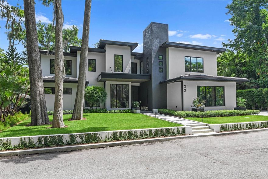 Exquisite contemporary waterfront retreat in Maitland. Experience modern luxury and serene waterfront living in this breathtaking five-bedroom, 5.5-bath canal-front home, newly built in 2024. Positioned on a quiet dead-end street in Maitland, this architectural masterpiece offers an unparalleled lifestyle on the Winter Park Chain of Lakes. Enter through the stunning 10-foot glass pivot door into a soaring foyer where a floating wood and glass staircase sets a dramatic tone. The expansive great room boasts a two-story ceiling and a wall of glass doors that seamlessly blend indoor and outdoor living. Go outside to your private oasis featuring a covered lanai with remote-controlled screens, a summer kitchen, gas fireplace, resort-style pool and spa, putting green, and a covered boat dock with a lift and jet ski platform, all overlooking tranquil Howell Branch Creek with direct access to Lake Maitland. The heart of the home is the chef-inspired kitchen, complete with dual oversized islands, sleek high-gloss custom cabinetry, integrated refrigerator and freezer columns, a wine refrigerator, built-in coffee maker, and a striking hood vent above a six-burner gas range. Adjacent is a stylish dining room framed by a floor-to-ceiling glass wall offering captivating water views. The main-level primary suite is a sanctuary with a private sitting area, dual walk-in closets, and a spa-style marble wet room with combined soaking tub and rainfall shower. A home office with lush front yard views, an elegant guest suite, a full bath, and the first of two laundry rooms complete the first floor. Take the elevator or statement staircase to the second level, where you'll find two additional bedrooms with en suites and walk-in closets, a fifth bedroom, a full bath, a second laundry room, and a 24-by-14-foot game room with wet bar, ideal for entertaining. Additional highlights include a three-car side-entry garage, an outdoor shower, a storage room, and verdant landscaping adorned with majestic cypress and oak trees draped in Spanish moss. Just minutes from the boutiques and fine dining of Winter Park’s Park Avenue, with easy access to major highways, hospitals, and both international and executive airports. This is Florida luxury redefined, private, peaceful and perfectly appointed.