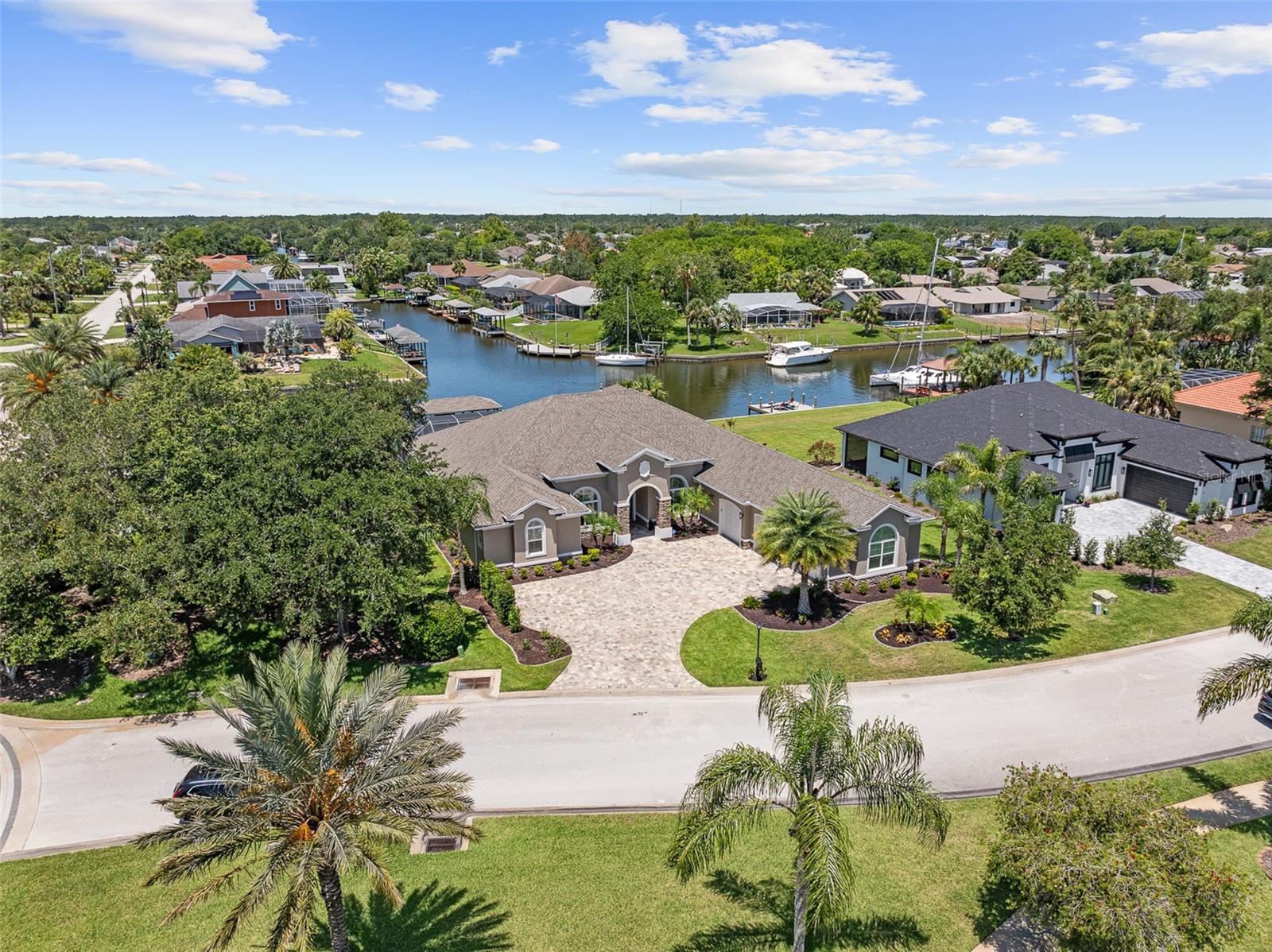 Luxurious Waterfront Living nestled in the prestigious, gated community of The Sanctuary, this stunning custom-built home (2021) seamlessly blends refined luxury with everyday functionality and exceptional saltwater canal access. Spanning 4,225 square feet, the residence is thoughtfully designed to capture both comfort and elegance in every detail. The expansive primary suite offers a tranquil retreat with custom closets and a spa-inspired ensuite featuring designer tile and refined finishes. Throughout the home, soaring ceilings enhance the open, airy atmosphere—10 feet in the bedrooms, 12 feet in the main living areas, and up to 13 feet in tray ceilings. Entertain with ease in the chef’s kitchen, complete with 42-inch white shaker cabinetry, a large walk-in pantry, and generous counter space for hosting. The home includes four spacious bedrooms with ensuite baths, two half baths (including a dedicated pool bath), and a flexible in-law suite or flex space—ideal for multi-generational living or guest privacy. Interior features include real wood flooring, plantation shutters, electric blinds, a gas fireplace with multi-speed fan, central sound system, central vacuum, and thoughtfully placed floor outlets for convenience. The laundry room is equipped with a washer and gas dryer. Step outside to your private waterfront oasis, where outdoor living takes center stage. Enjoy a chlorine pool, covered boathouse, 222-volt power at the dock, and a 10,000 lb boat lift. The property is pre-wired for a portable generator with a 50-amp plug—perfect for peace of mind. Note: Fabric valances do not convey.This is a rare opportunity to own a fully appointed, meticulously maintained waterfront retreat in one of Palm Coast’s most exclusive communities. A true gem for those seeking elevated coastal living.