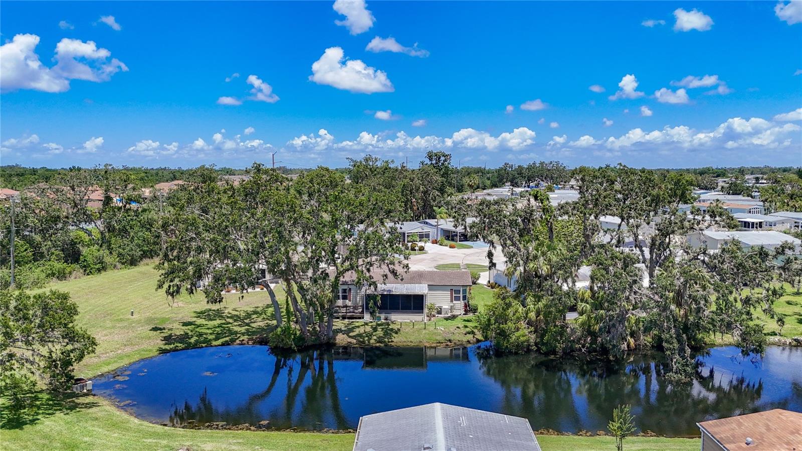 SPACIOUS HOME IN LAND OWNED, ACTIVE 55+ COMMUNITY! Start enjoying your Florida life in this two bedroom, two bath home with water view. This home is truly a blank slate that you can personalize and make your own. When you enter, there is a proper mudroom with storage and a pantry closet. The galley kitchen leads to the dining room where lighted built-ins provide even more room to display your treasures. The ample living room has sliding doors that open to the rear lanai. The lanai has an attached deck and overlooks a serene pond. Enjoy bird watching to your heart's content! Split bedroom floor plan gives privacy to the bedrooms. Both bedrooms have en suite bathrooms and enjoy water views. Laundry is conveniently located in the primary bathroom. Custom, stained glass windows are displayed throughout the home. Skylights in several rooms. There is a large shed off the breezeway that makes a perfect workshop. Attached one car garage and space for golf cart parking. The golf cart is also included. Quarterly fees of $731/quarter includes 24-hour guarded gate, cable, internet, trash & grounds maintenance. The PET FRIENDLY community of Ridgewood Oaks features a heated pool & spa, pickleball & tennis courts, shuffleboard, clubhouse, outdoor exercise equipment, and many activities and opportunities to make friends. This home may also be leased with no waiting period making it a possible investment property. Close to I-75, outlet mall, library, dining, retail, and worship. SO MUCH TO OFFER!