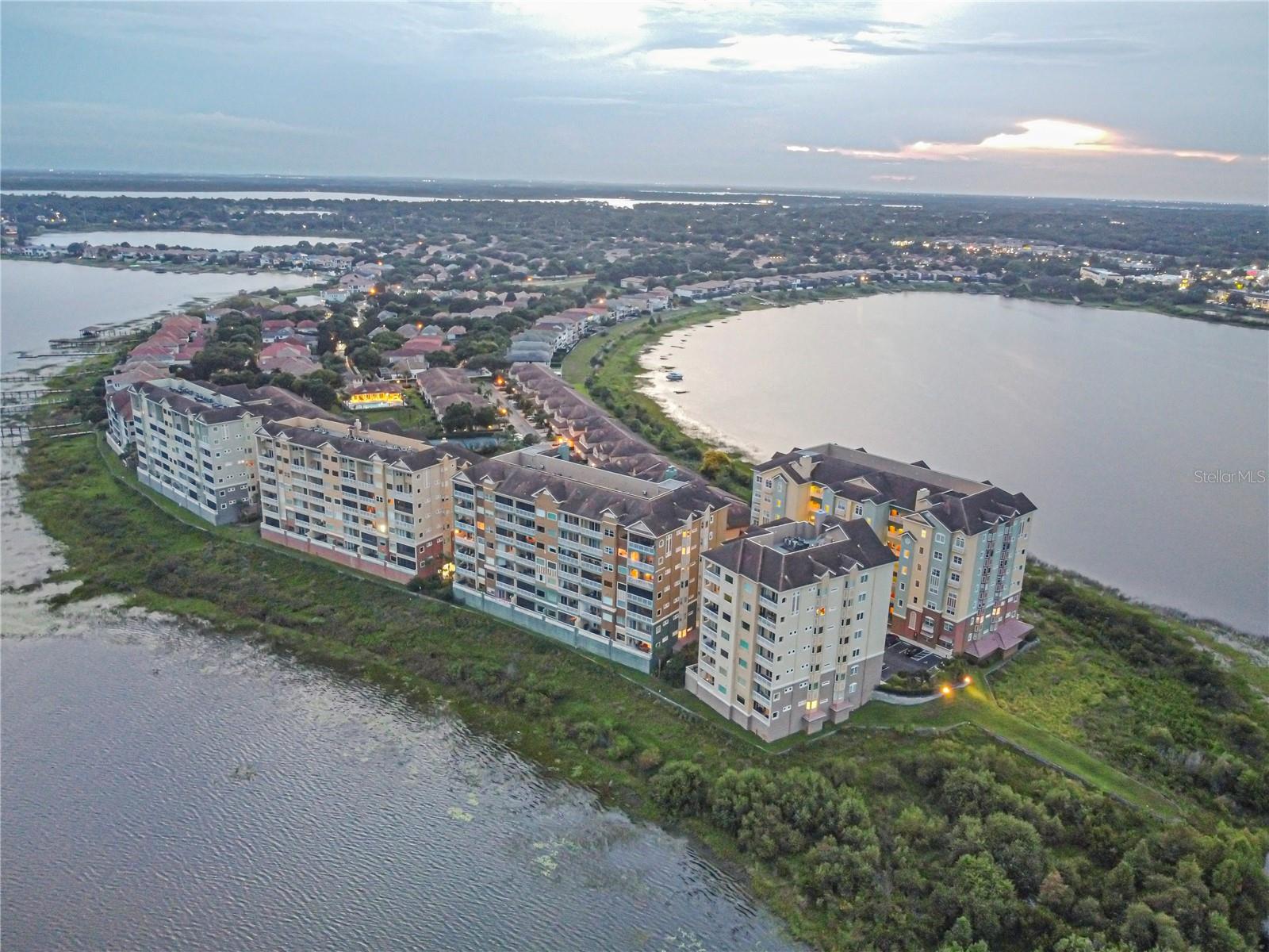 One or more photo(s) has been virtually staged. Welcome to your dream home in the award-winning, 24-hour manned gated community of Vizcaya, nestled in the heart of Dr. Phillips. This stunning 4th-floor lakefront condo offers breathtaking panoramic views of Big Sand Lake, with a spacious balcony perfect for watching nightly Disney fireworks light up the sky. Designed to impress, this home features an open-concept floor plan with granite countertops, 42-inch cabinetry, stainless steel appliances, and custom built-in closet shelving throughout. Large windows throughout flood the space with natural light, creating a bright, airy atmosphere and capturing stunning lake views from multiple rooms. The primary bedroom overlooks Big Sand Lake and includes custom built-in closets, offering a peaceful, luxurious retreat. The secondary bedrooms enjoy tranquil views of Little Sand Lake. Resort-style amenities include two tennis courts, a lakefront clubhouse with fitness center, and a pool with hot tub and cabana. The condo also includes assigned garage parking with additional storage for added convenience and security. Ideally located near Disney, Universal, the new Epic Universe, and Orlando International Airport, plus within walking distance to famed Restaurant Row and zoned for A-rated schools, this home offers the perfect blend of location, lifestyle, and lakefront luxury. Don’t miss your opportunity to own a piece of paradise in one of Orlando’s most sought-after communities.