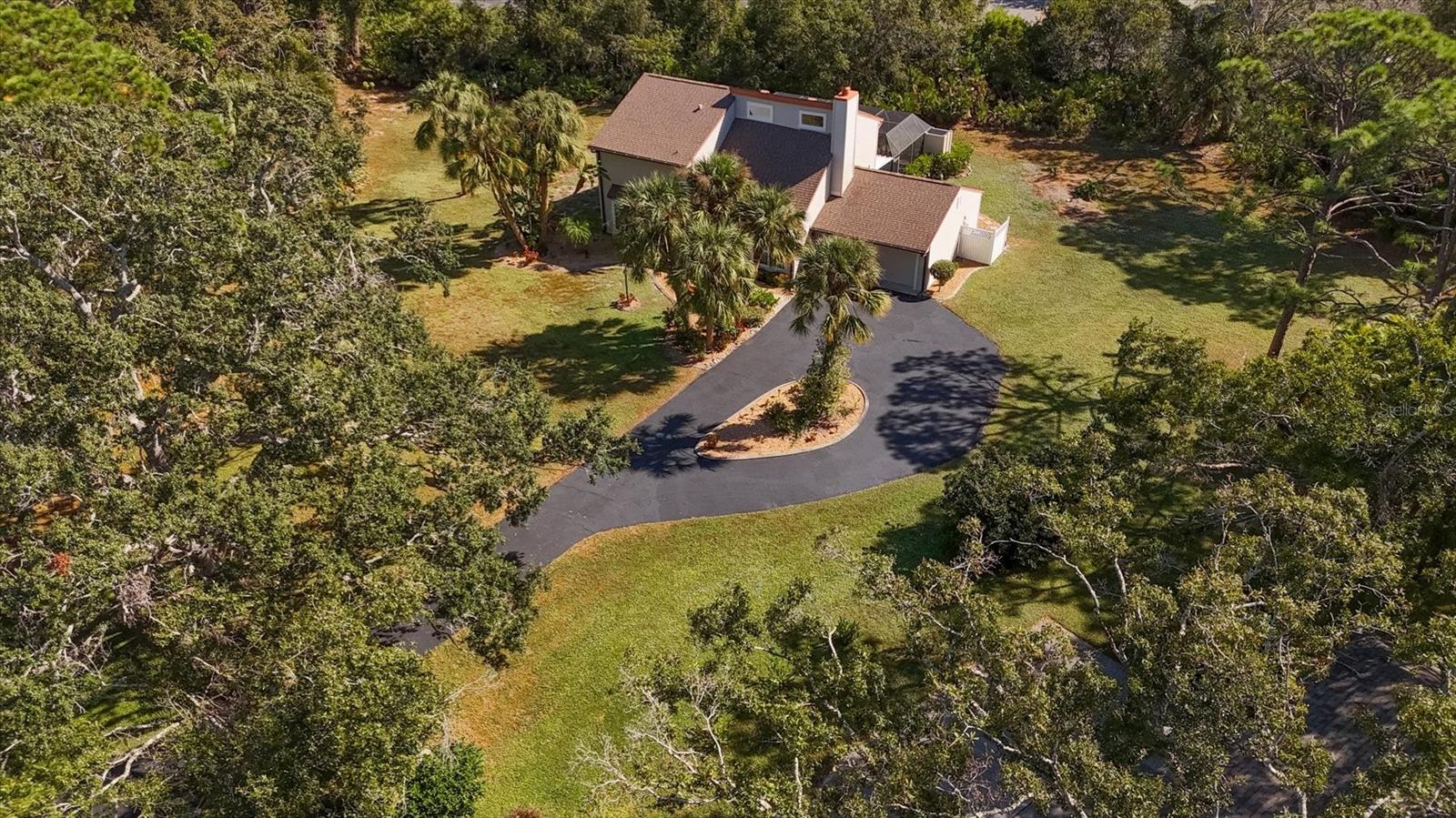 Spacious two-story pool home on over one acre in the desirable Ravenwood neighborhood! This updated 3-bedroom, 2.5-bath residence offers 2,156 sq. ft. of air-conditioned living space and a flexible layout designed for comfort and entertaining. Enjoy peace of mind with a 2025 water heater,  screen enclosure, and a deck overlooking the private, tree-lined yard. Features include consistent tile flooring throughout upstairs and main floor, 2007 Windows and Doors, a newer kitchen with Thomasville cabinetry, Bosch dishwasher, GE dual oven range, and wine cooler. The first-floor primary suite provides ease and privacy, enhanced by a walk-in closet and bay window that fills the room with natural light. The first floor living room features a cozy fireplace and its own bay window overlooking the front yard. Upstairs is a full bath, two additional bedrooms each include walk-in closets, and a loft area that provides an inviting gathering space with sliding doors that open to the upper deck. Outdoor living space has a covered lanai, with a heated pool, screened paver deck, and outdoor shower — perfect for year-round enjoyment. The oversized garage includes laundry and a reinforced garage door and custom flooring with a exterior door to the back. Vinyl siding, a generous driveway, and a low annual HOA of $222 yrly add to the appeal. No rentals allowed. Set on a 1.09-acre lot backing to a quiet church property, this home combines privacy, thoughtful updates, and a convenient Sarasota location just off Desoto Road between Lockwood Ridge and University Blvd.