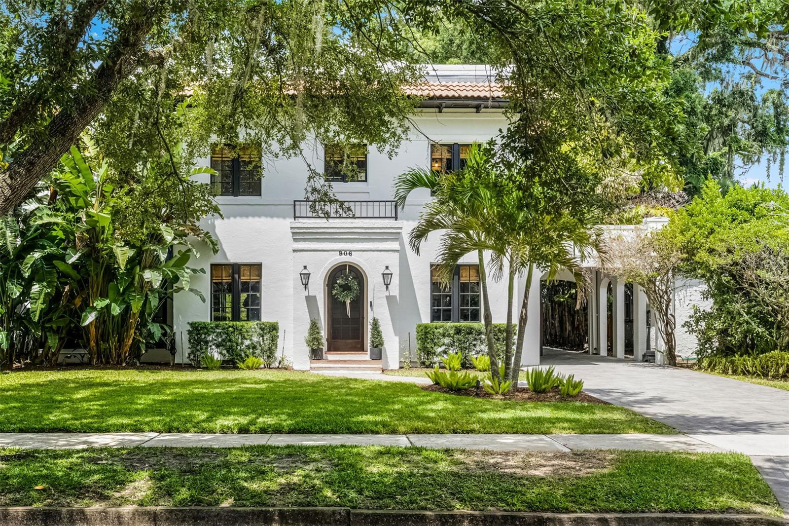 Timeless elegance meets modern luxury in this breathtaking Mediterranean Revival masterpiece, located just one block from Lake Adair in the heart of College Park. Set on a rare double lot, this fully renovated home offers an extraordinary blend of historic charm, high-end finishes, and resort-style outdoor living rarely found in the area. A paver driveway and arched Port Cochere set a gracious tone, welcoming you into interiors that exude character and warmth. Rich hardwood floors flow through the spacious formal living and dining rooms, where classic architecture is accented by thoughtful upgrades like a built-in buffet with wine refrigerator—ideal for entertaining in style. The designer kitchen is a showstopper, outfitted with a Wolf gas cooktop and hood, Bosch and GE Profile appliances, a commercial-grade ice maker, undercounter refrigeration, and a quartz-topped island lit by stylish pendant lights. Just beyond, the light-filled family room offers seamless access to the outdoor sanctuary through elegant French doors. A first-floor en-suite bedroom with private exterior entry and access to the backyard offers a perfect setup for guests, in-laws, or multigenerational living. A charming sunroom with French doors provides the ideal home office or creative space, while a stylish powder bath completes the main level. Upstairs, the luxurious primary suite features a walk-in closet plus two additional closets, and a beautifully appointed en-suite bath. Two more generously sized bedrooms include walk-in closets, with one offering private access to the newly renovated full bath. Downstairs, you’ll also find a partial basement, offering valuable storage space rarely found in Florida homes. Outside, the backyard is nothing short of spectacular—a private retreat designed for relaxing, entertaining, and enjoying the Florida lifestyle. The expansive travertine patio wraps around a resort-style pool, leading to a covered lanai with ceiling fans, an inviting outdoor living room, and a fully equipped summer kitchen with built-in grill, burner, sink, and beverage fridge. Enjoy a round on your custom putting green, gather around the built-in fire pit, or rinse off under the outdoor shower, all surrounded by lush landscaping and privacy hedges that create a true backyard oasis. Set in one of Orlando’s most beloved neighborhoods, you’re just moments from Edgewater Drive’s dining and shopping, Downtown Orlando, AdventHealth, and scenic lakes and parks.