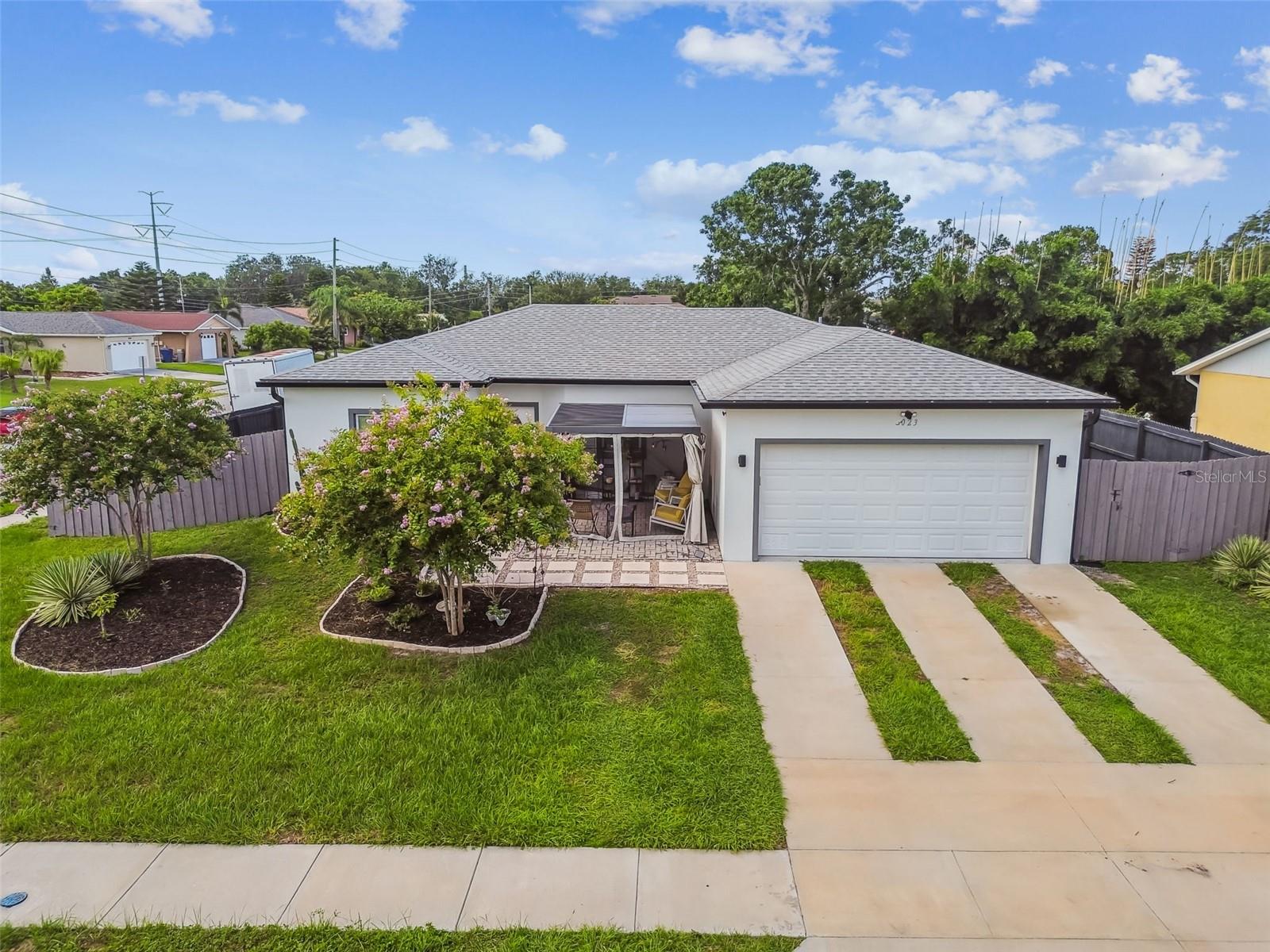 LIKE NEW - MOVE IN READY - NO HOA - MUST SEE. Built in 2021, do not miss this beautifully designed home located on a sweeping private corner lot located in a central location in Holiday, Florida! This 3 bedroom, 2 bath, 2 car attached garage home presents a fresh new feel with all that a new construction home offers without the wait. This great room, split floor plan offers a nice open design perfect for entertaining your family or friends. The kitchen is the heart of the home featuring a large center island with room for 4 bar stools, granite countertops, custom cabinets with soft close features, under mount stainless steel sink, stainless steel appliances and plenty of cabinets for your kitchenware all overlooking the GREAT ROOM. The primary suite is spacious with a corner desk or dresser niche, upgraded light fan package, oversized walk in closet, primary bath with quartz vanity countertops, double sinks, walk in shower and designated linen closet. Additional highlights of this home include a FENCED IN BACKYARD, front paver patio, HURRICANE RATED WINDOWS, recessed lighting, upgraded ceilings fans, laminate floors consistent throughout, ceramic tile floors in the baths, inside laundry room including the washer and dryer, gutters, tropical backyard with fruit trees and more. This home is centrally located to schools, shopping, beaches, restaurants, golf courses, Anclote Key State Park, Fred Howard Park, the famous Tarpon Springs Sponge Docks and approximately 45 minutes to Tampa International Airport and/or St. Peter/Clearwater International Airport. If you are looking for FLORIDA COASTAL LIFESTYLE without any HOA fees, this is the HOME FOR YOU.