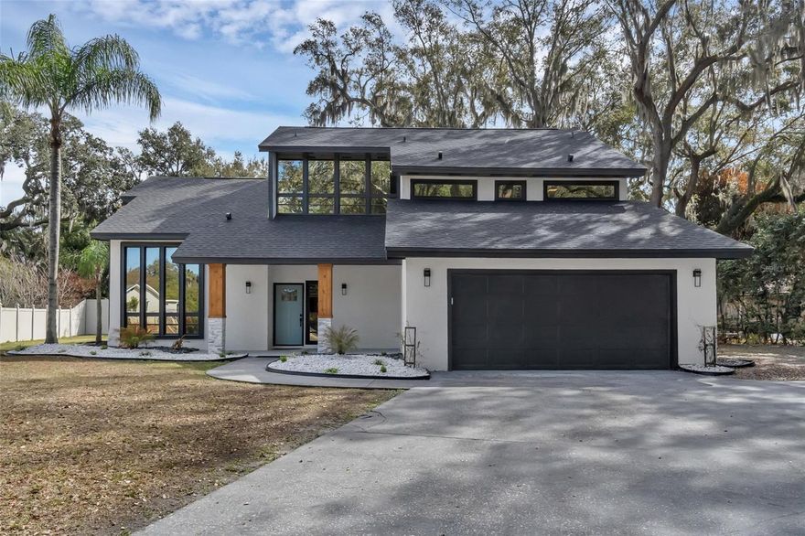 Fully renovated from top to bottom, this 4-bedroom, 3-bath home offers 2,760 square feet of thoughtfully redesigned living space on a spacious .35-acre cul-de-sac lot — with no HOA. From the moment you enter, the home makes a statement. A striking glass staircase sets the tone, adding architectural interest and modern edge that immediately separates this home from the ordinary. An abundance of newly installed lighting fills the space with bright, natural warmth, while wide-plank luxury vinyl flooring runs seamlessly throughout for a clean, cohesive look. The kitchen was designed to impress and perform — featuring brand-new cabinetry, sleek quartz countertops, stainless steel appliances, and a generous island that anchors the room. It flows effortlessly into the open-concept living area where a remodeled fireplace adds warmth and balance to the contemporary finishes. The primary suite feels like a private retreat. With two access points — including a dramatic spiral staircase — the space offers flexibility and character rarely found at this level. The spa-inspired primary bath delivers a true oasis feel, complete with a freestanding soaking tub and dual shower heads designed for a luxurious, everyday escape, while each bathroom showcases brand-new custom tile showers, modern vanities, and quartz countertops that feel straight out of a design magazine. All four bedrooms offers comfortable, usable space, and each includes a custom closet system for elevated organization and functionality. Major updates have already been handled: brand-new roof, fresh interior and exterior paint, and a newly resurfaced pool provide both style and peace of mind. Step outside to a large covered patio overlooking the pool and jacuzzi — a true Florida backyard built for entertaining or unwinding year-round. The oversized driveway and 2-car garage allow for multiple vehicles, guests, or recreational toys, while the expansive lot still leaves room to breathe. Architecturally distinctive, fully updated, and positioned on a generous lot in a prime area, this is the kind of home that stands out — especially at this price point. Experience it in person and see why it feels different the moment you walk in.