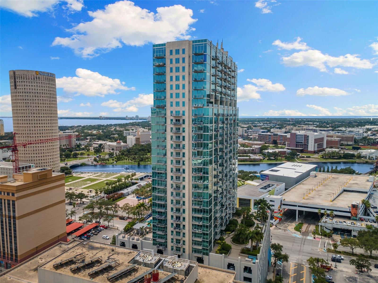 Welcome to a life of elevated urban luxury at SkyPoint, where the city’s most breathtaking views become your everyday backdrop. This rare 25th-floor corner residence has been completely reimagined by one of Tampa’s premier interior designers, offering a sophisticated two-bedroom, two-bathroom sanctuary. Ten-foot floor-to-ceiling windows frame unforgettable southern exposures of the downtown skyline, Tampa Bay, the Hillsborough River, and the Garrison Channel, inviting you to greet the day with majestic sunrises from your private balcony.
The transformation is immediate, with wide-plank flooring flowing throughout the main living areas and plush carpeting in the bedrooms, all selected for modern elegance. The thoughtful redesign includes integrated remote-controlled sunshades and a spacious layout perfect for both grand entertaining and daily living, featuring a dedicated dining area and an oversized laundry room with ample storage. The renovated kitchen is a highlight, appointed with fresh quartz countertops, a sleek tile backsplash, new stainless-steel appliances, and a central island.
Your residence includes two conveniently assigned parking spaces on the third floor of the secured garage. SkyPoint itself redefines resort-style living, with a 24-hour concierge and controlled access ensuring privacy and security. The eighth-floor amenity deck features a heated pool, a saltwater hot tub, multiple outdoor grilling stations, an outdoor kitchen, and a beautifully landscaped park in the sky. Inside, find a state-of-the-art dual fitness center, a residents' clubhouse with a catering kitchen and bar, lounges, and a private theater room.
Embrace the vibrant energy of downtown Tampa from your front door, with the cultural arts district, Curtis Hixon Park, and the Tampa Riverwalk directly outside. You are moments from the city's best attractions, with easy access to the trolley, water taxi, and Tampa International Airport. This meticulously renovated residence is your gateway to the very best of Tampa, offering a turnkey experience in a world-class location.