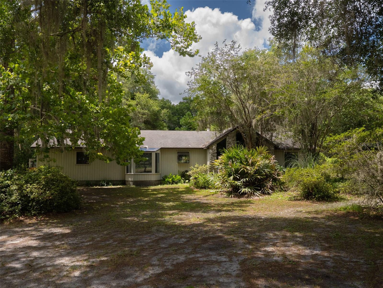 Secluded 3-bedroom, 2-bath home offering 1,764 heated and cooled square feet on a beautiful 10-acre parcel just minutes from historic downtown Melrose and a short 20-minute drive to Gainesville. The home features a welcoming foyer with a cozy nook, a spacious living room with vaulted ceilings, abundant natural light, and a fireplace, plus a skylit dining area off the kitchen overlooking the naturally landscaped front yard. The primary suite includes a sunroom with serene backyard views, and the open rear patio features a water element perfect for relaxing outdoors. Additional highlights include an oversized utility room ideal for crafting and a one-car garage. Schedule your tour today!
