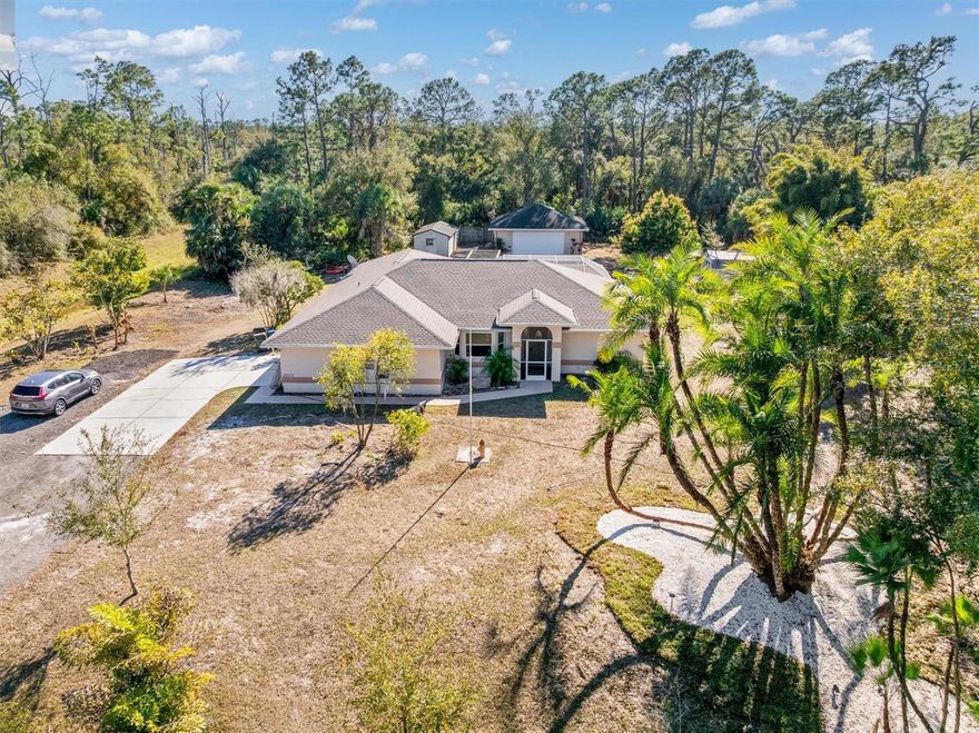 RARE OPPORTUNITY IN THE NORTH PORT ESTATES! BEAUTIFULLY UPDATED 3-acre parcel POOL HOME with 3 bedrooms, 2.5 baths, 2 car attached garage with side garage entry and half circular driveway, PLUS A DETACHED 30x30 4 CAR CONCRETE BLOCK GARAGE with over 2000 sq. ft of LUXURY living space! ANIMALS & HORSES WELCOMED! The air-conditioned 2 car garage is currently being used as a game room with wall a/c and includes a half bath. Hobbyists & Car enthusiasts will love the covered space to store cars, trucks and all the big toys! Pool table included! Located in one of the most desirable North Port Estates neighborhood, this HEATED in-ground pool home delivers space, style, and flexibility in one exciting package. New items include NEW Roof (2023), NEW well pump, Re-piped plumbing (2025), NEW wood cabinetry with slow close feature, solid surface countertops, NEW glass tiled backsplash, NEW accent lighting, eye-catching chandelier and light fixtures, NEW stainless faucet, NEW paint, NEW crown molding, NEW laminate waterproof plank tile flooring through out, NEW sleek stainless hood stack, NEW whirlpool range, dishwasher, washer & dryer, deep walk-in pantry & more! Through the etched glass front door, the home opens to a formal living room with decorative pillar and formal dining room with modern NEW LED lighting and dining room chandelier, enhanced by a bump-out window and classic chair railing trim. These spaces create a bright and open first impression and flow smoothly into the heart of the home. Recessed lighting adds a clean look, while the large breakfast bar and pass-through window to the lanai make entertaining easy. A deep pantry and reverse osmosis system under the sink add smart convenience. The spacious family room and dinette area feature sliding doors that lead to the Florida room, finished with durable laminate waterproof flooring and views of the pool area. This space blends indoor comfort with outdoor living, making it a favorite spot year-round. Occasionally a friendly deer will walk by to visit! The heated in-ground pool invites relaxing afternoons and fun-filled evenings, with direct access from the guest bathroom for added ease. The primary bedroom includes a large walk-in closet, ceiling fan, & sliding doors to the Florida room. The private updated bath showcases UPDATED dual sinks with modern lighting and mirrors, Corian countertops, and a walk-in shower with a glass door. Two additional bedrooms also feature walk-in closets and ceiling fans, offering generous space and comfort. Waterproof laminate flooring runs throughout the entire home, paired with beautiful NEW modern light fixtures that add a fresh, updated feel. The laundry room is oversized and includes a modern new washer and dryer, numerous storage cabinets, and a utility sink. A half bathroom in the garage/game room adds extra functionality. Outside, the property truly shines. A detached 4 garage in the back, ideal for a workshop, hobby space, or extra storage. 2 storage sheds and ample parking space complete the outdoor setup. Located close to the new SMH Hospital being built, schools, shopping, restaurants and the Atlanta Braves training stadium. This special home combines privacy, convenience, and lasting value. Location is minutes to Myakkahatchee environmental park where hiking, jogging, fishing, canoeing, biking and picnicking are welcomed. Easy quick access to I-75. Schedule a private tour today!