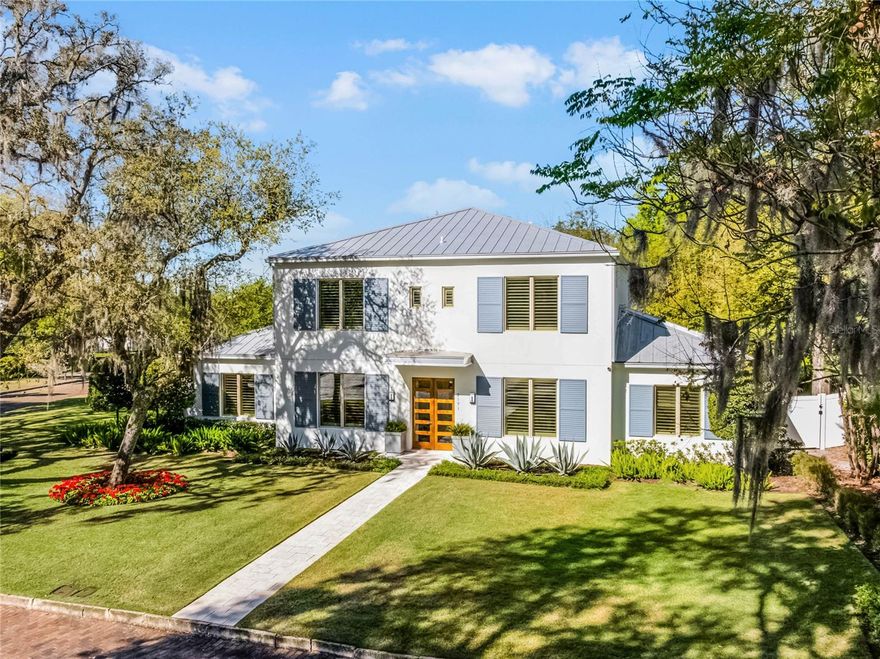 On one of Winter Park’s most scenic brick-lined streets, this exceptional two-story residence commands attention on a spacious corner lot, blending timeless architectural elegance with modern luxury. Built in 2016 by the highly regarded Rex-Tibbs Development & Construction, the home showcases quality craftsmanship throughout, from its striking curb appeal to its impeccably appointed interiors. A three-car side-entry garage, air-conditioned and offering generous storage, is connected to the home via a covered walkway, adding functionality and charm. Inside, beautiful wood floors extend seamlessly throughout the entire home, including all bedrooms, creating a warm, cohesive atmosphere. The main level offers an elegant formal dining room and a flexible front room that can serve as a home office, library or formal living area. The heart of the home is the expansive family room, anchored by a gas fireplace and illuminated by natural light through large sliding glass doors that open to the lanai and pool. Overlooking the family room, the open-concept kitchen is a culinary dream, featuring a Wolf six-burner gas range with double ovens, Sub-Zero refrigerator, abundant cabinetry and expansive counter space, ideal for everyday living and entertaining. The first-floor primary suite is a retreat, with French doors leading directly to the pool area, a luxurious spa-style bath, and a custom 14-by-10-foot walk-in closet designed for maximum organization and style. A secondary primary suite, also on the main level, includes a generous walk-in closet and a private en-suite bath, offering flexibility for guests or multigenerational living. Upstairs, the home continues to impress with a spacious recreation/game room, a separate bonus room and three additional bedrooms, all of which feature en-suite baths and walk-in closets, ensuring comfort and privacy for family and visitors alike. Step outside to experience resort-style living at its finest. The covered lanai is equipped with a fully outfitted summer kitchen, including a built-in grill, while the pool area is a showstopper, complete with a dramatic gas fire display, tranquil waterfall, ambient lighting, and a lush wall of bamboo that enhances privacy and lends a tropical ambiance. A separate outdoor cabana with TV and seating area offers a place to unwind or entertain in style. Beyond the home, the location is unbeatable. In one of Winter Park’s most desirable neighborhoods, you’re just minutes from the upscale shops, fine dining and cultural attractions of Park Avenue. The home is also conveniently close to top-rated public and private schools, premier medical facilities and major transportation hubs, including the Orlando Executive Airport and Orlando International Airport, ensuring ease of access for business and leisure travel alike. This remarkable property offers the ultimate in refined living, combining luxury, comfort and convenience in one of Central Florida’s sought-after communities.