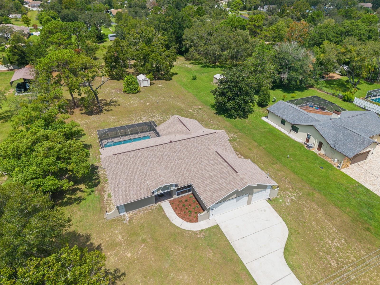 Sitting on a 0.86 acre lot, this absolutely gorgeous fully renovated POOL home is now available! Worry free here as the ROOF IS BRAND NEW! Upon entry into this home, you are greeted with an open living room, tall ceilings, and a direct view of the pool through the fully collapsible pocket sliders. With brand new flooring throughout and tons of natural light, this home feels so spacious and inviting. The stunning kitchen is a chef's dream! All new soft close cabinets, luxury countertops, new stainless steel appliances, a deep sink, and a giant breakfast bar. Sharing a room with the kitchen is a second full living room - perfect for entertaining! There are multiple dining options here in this home: the formal dining room, nook table in the kitchen, breakfast bar, or dine outside on the huge pool deck. The primary bedroom boasts a beautiful private view of the pool and backyard through the sliders. Featuring a huge walk-in closet and en suite bathroom, this primary is a true owner's retreat! The bathroom has a large brand new walk-in shower with frameless glass, a shower niche for storage, double vanities, and a separate water closet for privacy. Both guest bedrooms are generously sized and both have large walk in closets. One of the bedrooms has another set of sliders that lead onto the pool deck. The guest bathroom is also the pool bathroom, making for efficient use and convenience. This large sparkling blue pool has a brand new pool pump and new marcite! New pavers were just installed around the entire pool and lanai. Enjoy cooking outside on the grill, as there is a brand new outdoor sink station with cabinets and countertops to use! This home features a spacious laundry room with built-in cabinetry, a utility sink, and plenty of space for storage. Not only does this property have a 3 car garage, it also has an expansive driveway for parking multiple vehicles if needed! Additional items in this home that are BRAND NEW are: hot water heater, all interior doors, all baseboards, inside and outside paint, light fixtures, ceiling fans, and shelving. No HOA, No CDD, and No flood insurance required here! This location is a dream as it’s just 2 minutes to the Suncoast Parkway, Target, Publix, Walmart, and lots of restaurants. Hop on the Suncoast Parkway and you’ll be at Tampa International Airport in just 45 minutes. Come see this beautiful home in a highly desirable location!