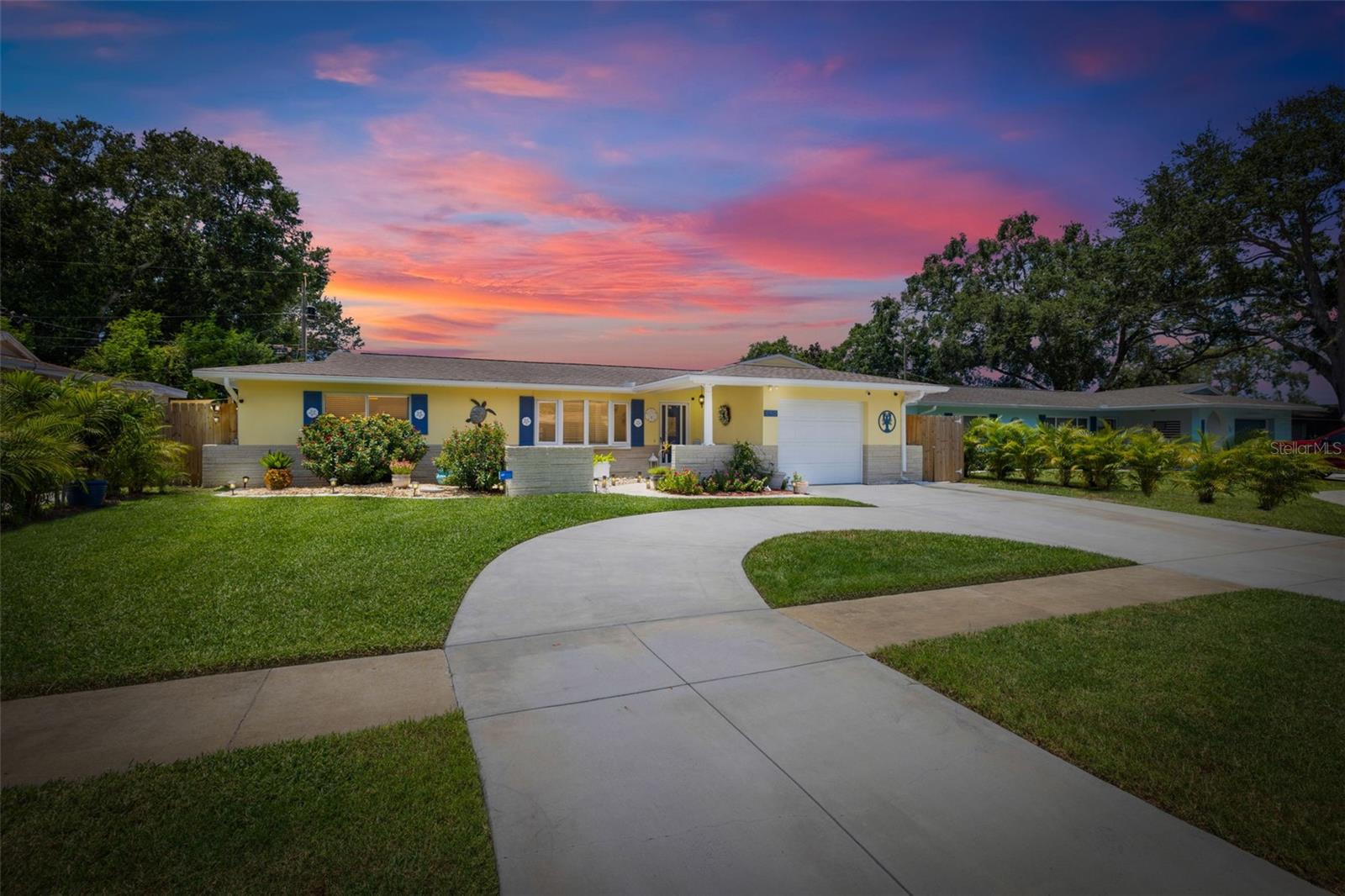Welcome Home to your Sunny Slice of Paradise! This beautifully updated 2-bedroom, 2-bathroom home radiates warmth and charm from the moment you arrive. Pride of ownership is abundant in every detail. Freshly painted inside and out in 2024, this home features incredible curb appeal with vibrant landscaping, coastal charm, and a circular driveway that welcomes you home. A single car garage is perfect for parking your car or storing your toys. Step inside to find spacious living areas filled with natural light. Wood and tile floors throughout the main living space provide easy upkeep. The Florida room is warm and cozy with a fireplace and a view of the lanai. Both oversized bedrooms have brand new carpet, offering comfort and flexibility for use of space. The main bathroom has been thoughtfully renovated with stylish finishes, creating a relaxing spa like feel. The heart of this home is the backyard oasis. Enjoy year-round relaxation in the screened-in lanai, complete with a sparkling pool, new chlorinator (2024), and plenty of room to entertain. The paver patio pool deck is a nice upgrade. The entire backyard is designed with low-maintenance Zeroscape landscaping and astroturf, perfect for those who want beauty without the upkeep. Additional updates include a new AC system (2024) and a roof replaced in 2019, offering both comfort and peace of mind. No flood zone here, this home stayed high and dry and unaffected by the storms. Largo allows for short term rentals with the proper permitting. Located in a friendly neighborhood close to shopping, dining, and only 15 minutes to the Gulf beaches, this home is move-in ready and waiting for its next chapter!