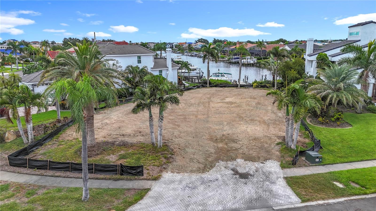 Welcome to Symphony Isles, a jewel within Apollo Beach—a hidden gem where waterfront living meets luxury and value. Bring your own builder and build the home of your dreams. One of the last few remaining canal lots, this prime property offers quick direct Tampa Bay access, water frontage with its own private dock equipped with water and electricity plus a 16,000# boatlift—perfect for hitting the water at a moment's notice. The cleared, level property is almost 1/4 acre, includes existing fill to help meet safe elevation and code requirements, a private landscape irrigation well, street sidewalk in place, and mature landscaping including multiple palms, all which represent huge savings and will reduce building costs. Utilities are on-site, and you'll save over $20,000 in additional county building fees as compared to other lots and thanks to added value features, you'll save even more. Be sure to ask about the extreme value this lot represents with it's approximate $100,000 in additional on-site extras. By boat, enjoy easy access to Tampa Bay, Downtown Tampa, Tampa Riverwalk, Amalie Arena, fine eateries, St. Petersburg, Sarasota, and world-class beaches. With easy access to major highways and airports, convenience is unmatched. Residents also enjoy premium amenities including a private year-round heated community pool, clubhouse, sand beach with activities, and a boat ramp. This exclusive 24-hour guard-gated community is known for its upscale homes, stunning sunsets, and exceptional value. ** Note: There was a catastrophic fire to the previous home and it was completely removed to make way for a new owner's vision. The county tax value listed will be inaccurate until the county updates its records, the value includes the previous home which is no longer there. **Vacant land rarely has an address or lot number posted. There have been occasions when a buyer has closed on a property and determined, after the closing, that the property conveyed to the buyer was not the property the buyer had visually identified prior to signing the contract. It is the buyer’s responsibility to confirm the legal description of the property the buyer wants to purchase prior to the end of the contract Property Inspection Period. The best way to accomplish this is for the buyer to obtain a survey that depicts a physical immovable object on the property or adjacent to the property that irrefutably confirms the property identified in the survey is the property the buyer wants to purchase.