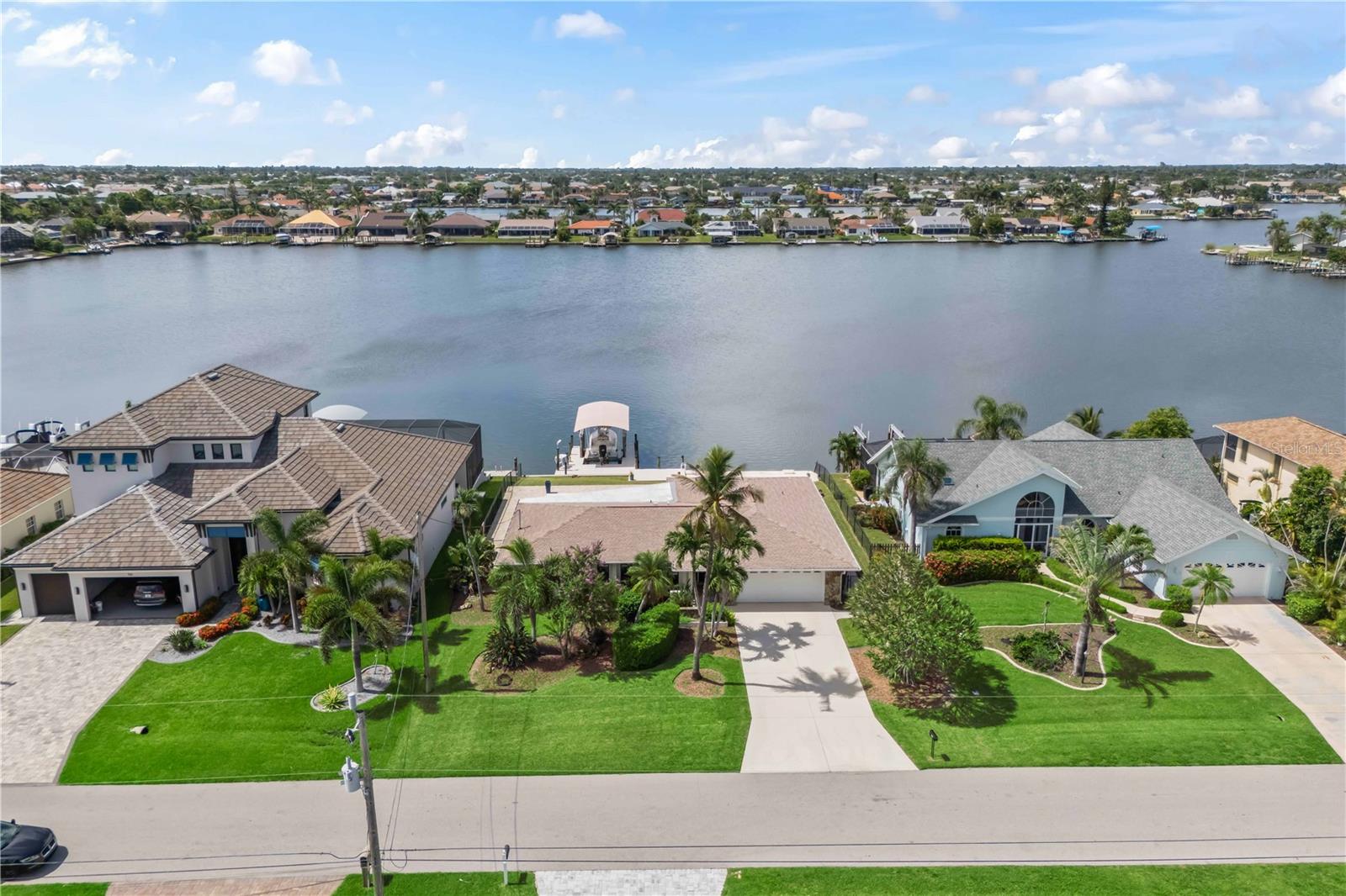 A VACANT LOT ON THE 8 LAKES JUST SOLD FOR $610,000 — FOR ONLY $95,000 MORE, THIS ONE COMES WITH A HOUSE! Lakefront Gulf-access pool home with premium upgrades and timeless Florida charm! Located on one of Cape Coral’s desirable 8 lakes, this beautifully remodeled property offers direct boating access to the Gulf along with a private dock featuring a 10,000-pound boat lift, upgraded 2” TanDeck decking, and a reinforced 4” concrete davit area—ideal for serious boaters. Inside, you'll find spacious bedrooms, abundant natural light, and modern finishes throughout. The indoor laundry room offers excellent functionality with ample cabinet storage and a granite countertop that’s perfect for folding. Other upgrades include a newer roof, a new pool pump, and a whole-house water softener with reverse osmosis system. The fully fenced yard adds privacy, and the pool area shines with a resurfaced deck finished in elegant Turkish Stone. Whether you're relaxing by the lake or heading out on the water, this home delivers the best of the Southwest Florida lifestyle.