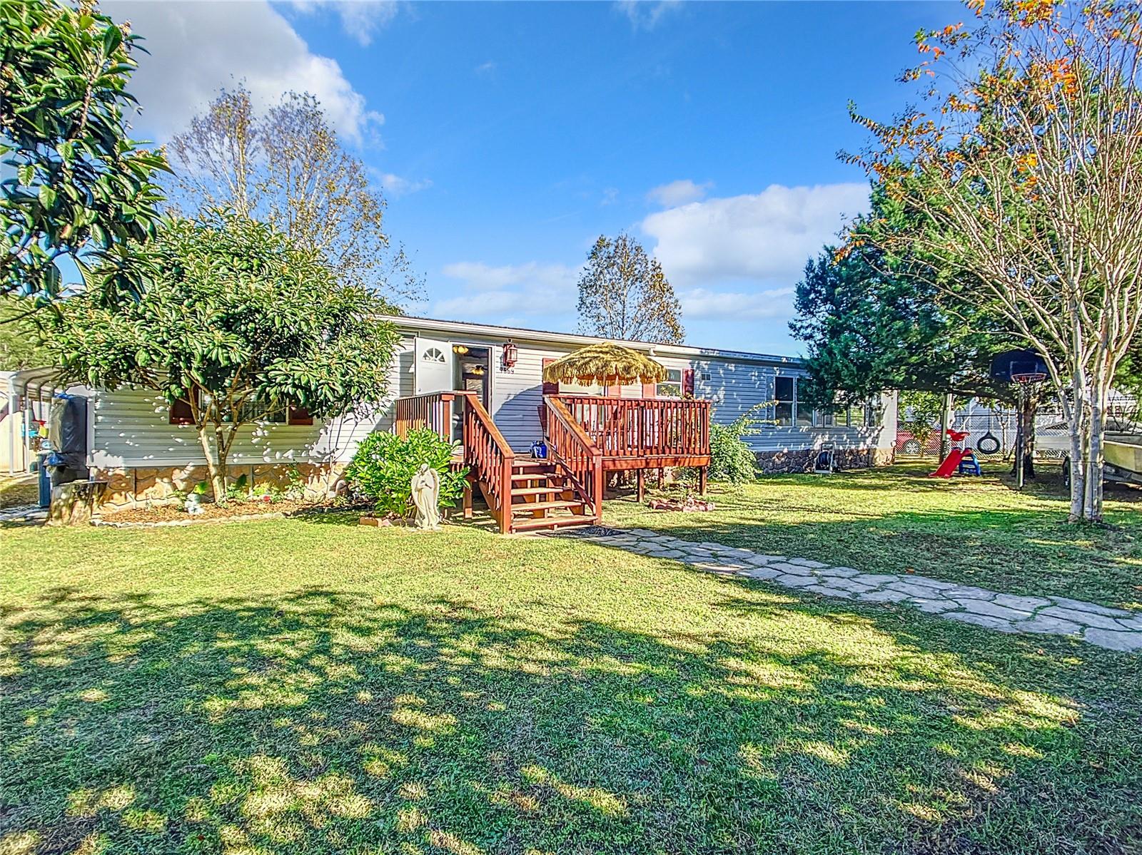 NOT IN A PARK. Sits on .22 acres of land. You will own the land as well. If you're searching for an affordable home in a central location, consider this 4 bedroom, 2 bathroom mobile home. Well-maintained and move-in ready, it features a small front deck and large covered patio perfect for morning coffee or family BBQs. The spacious, fully fenced yard provides ample room for gatherings. Roof (2011), (2011)HVAC system, inside laundry, gas stove, and on-demand water heater to reduce electricity costs. Just minutes from the World Equestrian Center, it's conveniently situated. Call today for more details on this great property! Cash or Conventional Financing Available.
