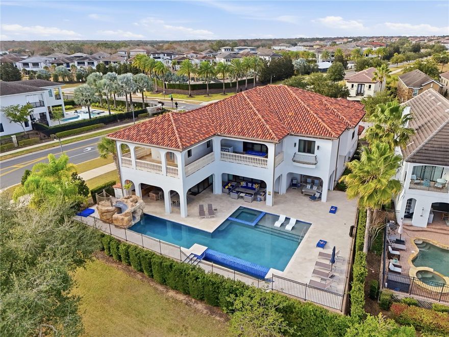 Ideally located within the award-winning REUNION RESORT and sitting on a DOUBLE CORNER LOT, this beautifully presented FULLY FURNISHED 8-bedroom, 9 full / 2 half bathroom CUSTOM BUILT home showcases panoramic GOLF AND WATER VIEWS of the 16th hole of Traditions golf course.  PROFESSIONALLY DESIGNED AND DECORATED with high end finishes and stunning built-in features abound, this luxurious TURNKEY ESTATE HOME has a meticulously thought thru’ floorplan and is perfect for entertaining on a large scale with its gourmet open plan kitchen, formal dining room (with seating for 12), home theater/media room, multiple lounge seating areas and fun arcade room. There is also a flex room with dedicated private balcony which can function as an office or a gym. The impressive foyer with DOUBLE HEIGHT entryway and sweeping double staircase adorned with an elaborate chandelier lighting fixture is simply breathtaking! There are TWO PRIMARY SUITES (one on each floor), 5 further spacious bedrooms as well as a bedroom consisting of two-double bunks, all are ensuite and have an abundance of closet and storage space. With a SUNNY SOUTH FACING ASPECT, the resort style outdoor area features a stunning INFINITY EDGE POOL WITH CASCADING FOUNTAIN, heated in-pool spa, WATERSLIDE and in-pool loungers all enhanced by an expansive PATIO/SUNDECK area with open as well as covered LANAI seating areas. Enjoy Florida outdoor living and lifestyle at its finest cooking on the grill in the OUTDOOR KITCHEN watching the early morning sunrise or evening setting sunset creating memories to last a lifetime. This residence can accommodate and provides ample parking space on its turnaround private driveway in addition to a functioning car garage which is a rare commodity within the community. With the added benefit of VERSATILITY OF USAGE, this stunning property is an ideal primary residence, second and/or vacation home and/or short term/long term rental and/or investment property! An ACTIVE TRANSFERRABLE MEMBERSHIP grants access to the many amenities of the Reunion Resort with its three world class golf courses (designed by Arnold Palmer, Tom Watson and Jack Nicklaus), a golf academy, Clubhouse at The Bear’s Den, six onsite restaurants, twelve community swimming pools, a multimillion-dollar water park with lazy river, six Har-True tennis courts, pickleball, bocce ball, volleyball, crazy golf, fitness center, a playground, and full-service salon and spa. Reunion has a variety of on-site dining options and is only a couple of miles away from Walt Disney World Resort, Seaworld and Universal Studios. 3D tour available. DON’T MISS OUT on this opportunity and schedule your private showing today!