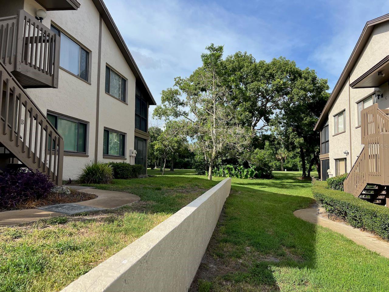 55+ second floor condo with excellent views of the serene and beautiful golf course. The open floor plan has an efficient kitchen, large enough for a small table. The is a open porch off the kitchen that is enjoyable for your morning coffee. The laundry facilities are in a closet in the kitchen so it is easy to prepare meals while doing a load of wash. This floor plan is open to the dining area and living room making it feel spacious. In addition, there is a cozy side room that was originally designed as the dining room. But most owners use this as extra space for crafts, reading or other activities. The bedrooms are split being in opposite ends of the unit so quiet and privacy are assured. The guest room has a full bath conveniently next to it. The primary bedroom has an ensuite full bath. There are views of the golf course and trees- very peaceful. The living room has a screened porch that also overlooks the golf course.
There is a dedicated carport to keep your car out of the sun and weather. The condo complex has its own pool, hot tub and shuffleboard as well as a community center. The condo complex is part of the much larger and desirable Beacon Woods. Beacon Woods is built around a picturesque golf course. The Beacon Woods community has winding roads and mature trees with many ADDITIONAL amenities such as: heated pool, lighted tennis and pickleball courts, basketball, play area, exercise room, bocce ball and more. The clubhouse has many activities including but not limited to: dances, cards, yoga, and seasonal gatherings. The monthly fee for this condo is only $410 per month that covers all this: exterior maintenance, garbage, water, sewer, cable tv with Internet, pool, shuffleboard and dues for the larger Beacon Woods community. Your only utility bill will be the electric you use. Sweet! There are maintenance personnel on grounds everyday in case the exterior of the condo complex needs attention. This condo has one of the best run Boards. Major upgrades have been made to the complex and the condo budget has sufficient reserves for future maintenance. There are no major improvements needed, keeping your monthly costs low with NO future surprises. All dimensions are approximate and buyer is urged to confirm items of significance to them. The furniture and ALL APPLIANCES ARE NOT included in the price. It is a joy to live here. This is one of the best values in this community. Buyers are urged to verify all information deemed important to them and to review association documents. All dimensions are approximate. The unit can be rented after 2 years of ownership.