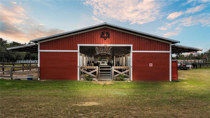 Discover a truly exceptional equestrian estate where the splendor of nature and the world of horses converge. This extraordinary property boasts five barns, an impressive total of 53 horse stalls, a modular home, RV/Trailor canopy with 2 RV hookups (there’s a total of 6 RV hookups on the farm), offering a rare opportunity for horse enthusiasts and those who appreciate the freedom of rural living. From the moment you arrive, the scale and charm of this horse farm are immediately apparent. The vast, open landscape is punctuated by meticulously designed and maintained barns, a haven for your equine companions. The barns are a testament to quality and functionality, providing ample space for housing, grooming, and caring for your horses. Each stall is a haven of comfort and security, ensuring the well-being of your beloved animals; lined with mats, and hooked up with fans. The main barn, 50x200 ft, is a recent construction built by the current owner with 32 stalls, a 2-ton lift, electricity, water, a concrete aisle, feed room, and it opens up to the pastures. On the topic of pastures, there are more than 14 fenced and cross-fenced pastures on the property, creating tons of opportunities for housing different livestock if that’s your preference. Near the main barn is a mini-horse barn, also newly constructed, that has 7 stalls, water, electricity, storage, and a sitting area. The events barn is massive, 75x180 ft, with tons of amenities. This barn boasts a built-in stage, an office, a full apartment (living room, kitchen, 2 bedrooms, 1 bathroom), a public bathroom, a huge tool room for storage, and 4 additional horse stalls. The barn has a new metal roof equipped with rainwater diversion to shift run-off water away from the barn. The third horse barn, 60x80 ft, has 12 horse stalls, a kitchen/med room, a storage room, an office, and a feed room. Rounding out the barns is a 40x50 ft hay barn, fully enclosed, with two sets of large sliding doors and tons of storage space. Beyond the equestrian facilities, the property features 6 RV hookups, making it a versatile venue for gatherings, events, or potential income generation. These hookups are ideal for accommodating guests, friends, or clients, creating opportunities for gatherings and horse-related activities. A newer modular home on the property provides 500+/- sq ft of living space with one bedroom and one bathroom. The rural charm and tranquility of this horse farm offers a peaceful retreat, yet it's not far from amenities and services. Being located on Highway 60, you’re close to the state fairgrounds for potential horse boarding, I-4, downtown Plant City, and not far from Brandon. This means you can enjoy the best of both worlds: the serenity of 26 acres of land and the convenience of the city. The possibilities for this property are endless. Whether you dream of operating a horse breeding or training facility, hosting events, converting into barndominiums, creating a veterinary hospital, or simply living in harmony with nature, this paradise provides a canvas for your vision. More of the property is wooded with some clearings that have been utilized for camping and storage, with 5 53’ trailers on the back end of the property providing additional storage on the property. Fifty-three total horse stalls, multiple barns, and 6 RV hookups await you. NOTE: GPS will likely take you to the wrong place, property is West of 39 and East of Mudlake Rd in Plant City on the North side of the road.