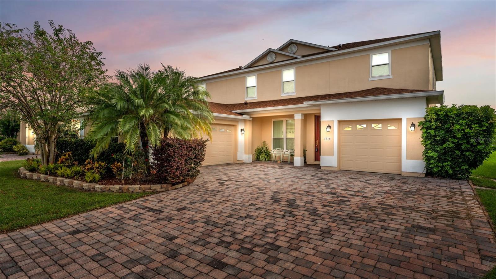 Welcome to this modern and fully furnished five-bedroom, three-and-a-half-bathroom luxury residence, offering the perfect blend of comfort, style, and functionality. From the moment you arrive, the pavered driveway, split three-car garage, gorgeous, landscaped yard, and stately two-story façade set the tone for the sophistication that awaits inside. Step through the front door to find a beautifully designed interior with large-format tile flooring, soaring ceilings, and a thoughtful layout ideal for both entertaining and everyday living. The home features separate formal living and dining rooms, providing refined spaces for hosting, while the open-concept kitchen and family room create a warm and inviting atmosphere for casual gatherings. The gourmet kitchen is a true centerpiece, showcasing granite countertops, a two-tiered breakfast bar, stainless steel appliances, pendant lighting, and a spacious walk-in pantry—perfect for the culinary enthusiast. With a double-primary suite design, the home offers exceptional flexibility. The downstairs suite is ideal for guests or multigenerational living, while the upstairs primary retreat provides a private haven alongside three additional bedrooms, all large in size, and a versatile loft/bonus area—perfect for a media room, playroom, or home office. The laundry room is spacious and fully loaded with cabinetry, a utility sink, and a fantastic tile wall behind the appliances. Enjoy Florida living at its finest on the screened-in lanai with ceiling fans, where you can relax and unwind in comfort and privacy. Immaculately maintained, the roof was replaced in 2023, recently replaced carpeting, the upstairs A/C unit was replaced in 2023, and new windows. Every detail of this home has been thoughtfully curated to provide a move-in-ready experience with timeless appeal. Luxurious, spacious, and impeccably maintained—this home is truly ready to welcome you.
