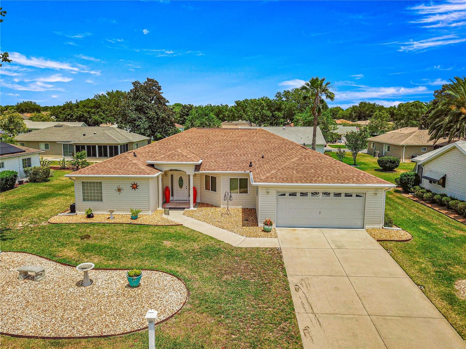 Here is your opportunity to purchase this meticulously maintained 3 bedroom, 2 bath Aspen floor plan in Del Webb Spruce Creek Golf & Country Club, a premier 55 plus community nestled in the heart of Summerfield, Fl. Just a short 10-15 minute drive to The Villages. This Aspen floor plan spans 2,342 sq ft under heat and air. The home exudes curb appeal with its easy to maintain vinyl siding, leaded glass entry door, and completely refreshed landscape. As you step inside, you will discover the heart of the home is an expansive open floor plan with both a formal living and dinning room, as well as a great room which is open to the kitchen and great for entertaining. The kitchen is ideal for hosting gathering with its bright white cabinets, and well-placed solar tube, enhancing the airy ambiance. The primary suite is a sanctuary, featuring an en-suite with double closets, a generous soaking tub, and updated walk in shower with direct access to the heated and cooled Lanai. Updates include some newer windows, full leaf guard gutter system, roof re-shingled in 2014, HVAC (2013), new stainless steel microwave, and refrigerator, and newer warm carpeting in the bedrooms. Both guest bedrooms are of ample size to allow privacy for guests. The vaulted ceilings amplify the sense of space throughout the main living area, while the split floor plan ensures privacy. The highlight of outdoor living is the enclosed, heated, and cooled lania with access from both the great room, and primary suite, providing the perfect setting for year round enjoyment.