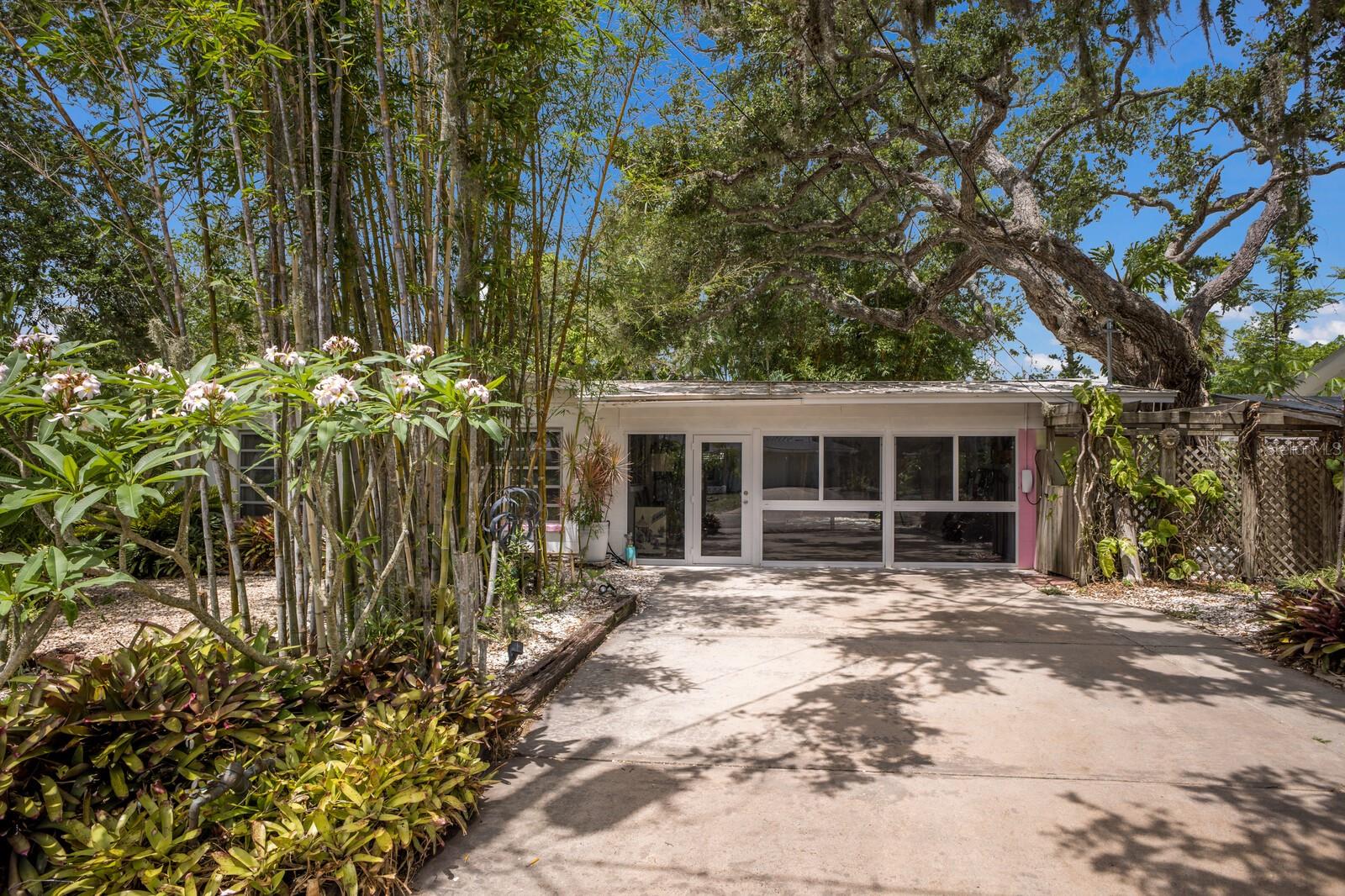Mid-Century Modern Charm Meets Lush Botanical Living in Sarasota!
Welcome to 2207 Hickory Avenue—a masterfully updated Mid-Century Modern gem nestled on a rare 10,000 sq ft double corner lot in the coveted Indian Beach Sapphire Shores neighborhood, just west of the trail. This turnkey 3-bedroom, 2-bath retreat seamlessly blends vintage character with thoughtful modern upgrades, creating a serene and stylish haven steps away from an open easement to Sarasota Bay.
Step inside to find gleaming original terrazzo floors and expansive open living spaces that invite natural light from every angle. The heart of the home is a fully renovated kitchen featuring striking quartz countertops, sleek cabinetry, brand-new stainless appliances, and a statement Chihuly-style chandelier that adds an artistic touch. The bedroom closets are cedar wood-lined, adding luxury and function to your everyday living experience.
An enclosed and cooled sunroom—adding approximately 400 square feet of additional living space- offers the perfect spot to relax, work, or entertain while enjoying lush garden views. The new central A/C system, including updated ductwork, ensures year-round comfort, and the durable metal roof provides peace of mind for years.
Outside, the grounds feel like a private botanical sanctuary surrounded by exotic bamboo, mature tropical landscaping, and fruit trees. Enjoy evenings soaking in the hot tub as the golden hues of a Sarasota sunset filter through the palms, or rinse off after a beach day in your private outdoor shower.
This home is being sold fully furnished—including all art and mid-century furniture—making it a turnkey opportunity. With space for four vehicles in the oversized driveway, walkability to Indian Beach, and proximity to downtown Sarasota, St. Armands Circle, and the cultural amenities of the Ringling Museum, this residence offers the perfect blend of tranquility, style, and convenience.