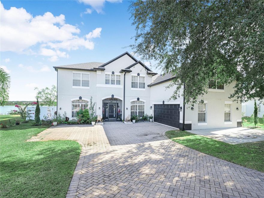 Welcome to your dream home! Offering over 3,500 square feet of living space and endless possibilities. This impressive property features 5 bedrooms, 4 bathrooms, a large bonus room, and soaring 9.5-foot ceilings throughout. Enjoy Florida living at its best with a pool and large enclosure, all set on over half an acre of waterfront property with a dock. This is just the start! As you arrive, you’re welcomed by a large paver driveway, an extra concrete slab perfect for additional parking or a sitting area, and a two-car garage. Step inside to an open entryway located next to the dining area and a downstairs office. The spacious living area flows seamlessly into the breakfast nook and kitchen, creating an ideal space for gathering and entertaining. At the heart of the home, the kitchen is designed to impress with quartz countertops, with waterfall edges, and stainless steel appliances. A thoughtfully placed bonus bathroom just off the kitchen adds convenience and includes direct access to the pool deck. Outside, the pool is covered by a large 32’ x 21’ screened cage, complemented by a 750sqft travertine tile, screened pool deck extension added three years ago. A paver walkway leads to the 80ft long dock built in 2022, while the pool itself offers a peaceful waterfall. Rounding out the outdoor living space is a custom-built outdoor kitchen featuring a large built-in stainless grill with rotisserie. Two additional burners, and built-in mini refrigerators and a wine fridge. Additionally, a new shed added in 2022 for pool and lake gear. The primary bedroom is conveniently located on the first floor, featuring sliding glass doors to the pool deck, a spacious en-suite bathroom with a soaking tub and walk-in shower, his-and-her sinks, and a walk-in closet. Moving upstairs, you’re greeted by a large loft or second living room overlooking the pool and backyard. Above the garage, a 300-square-foot bonus room with a wet bar awaits—perfect for a game room, man cave, or home theater. Four bedrooms are located upstairs, including two connected by a Jack-and-Jill bathroom, with one of those rooms offering an attached bonus room. Throughout the home, baseboards, crown molding, and ceiling medallions and chandeliers highlight the exceptional attention to detail. Additional highlights include a 2025 water heater, a 2023 roof and fence, and a pool installed in 2011 with a new pool heater added in 2024. The home also features a 2022 A/C system for the first floor, tile flooring throughout the main level, and laminate wood flooring upstairs. Outdoors, the property boasts young fruit trees, including mango, guava, papaya, and passion fruit, just to name a few. Located on Lake Mabel, a private 75-acre lake with no public access, this home offers privacy and peaceful waterfront living. Schedule your showing today!