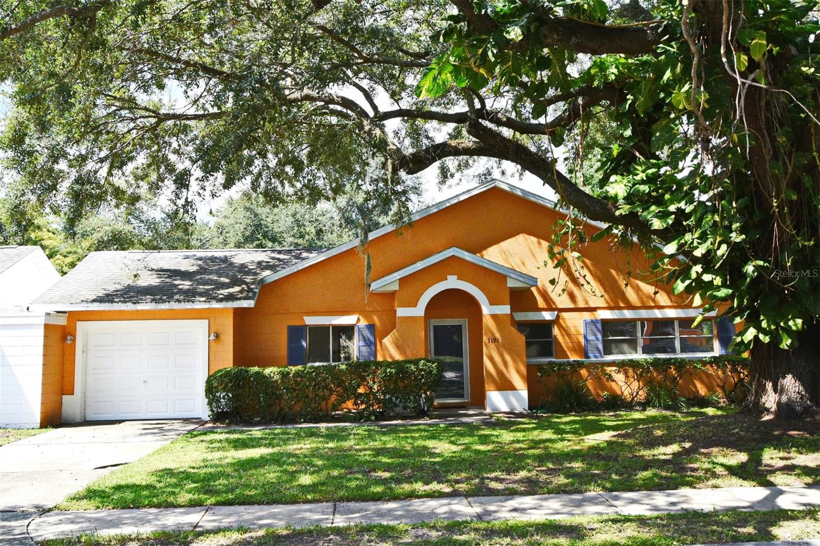 Military history home with a large screened-in (block half wall) porch on a generous sized lot (.21 acres), backing up to a private wooded area. This home contains a large storage/safe room that could possibly be converted into a tiny office & has numerous large windows creating fabulous light throughout. There is extensive closet & storage space including a designated laundry room. 1 car garage has a rear yard access door. Dedicated, secluded closet for air handler & hot water heater (2022) for peacefulness. The home has exposed terrazzo floors (cool & durable) in the bedrooms & most likely throughout the house under the tile. Tree shaded roof is the responsibility of the HOA and is not a homeowner responsibility saving thousands of dollars in potential replacement costs. HOA has 2 community pools & clubhouse(s) as well as playgrounds, basketball & volleyball courts. HOA low maintenance fee includes: front & side yard lawn maintenance, basic cable with HBO, exterior painting. The City of Orlando has hundreds of acres of parks- (Southport & Warren) in the area including jogging/walking trails, ball fields, playgrounds and other amenities. Close to Lake Nona, charter school(s) & OIA. This home is super cute and can be a real gem with minor upgrades and is listed at great price point which reflects associated costs to improve.