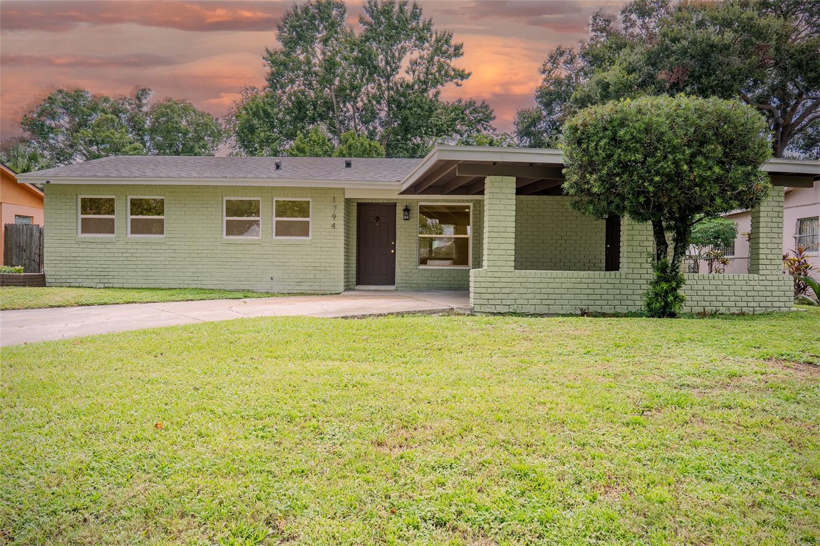 Check out this sweet home just minutes from downtown Orlando! Bursting with personality and curb appeal, this mint-green beauty has been thoughtfully updated with just the right dash of charm. Step into a light-filled interior where brand-new, warm wood-style floors lead into a dreamy custom kitchen featuring gold-flecked quartz countertops, a built-in refrigerator, brushed brass hardware, and a statement range hood that delivers major design impact. New energy-efficient windows flood the space with natural light, while the open-concept floorplan is ideal for both entertaining and everyday life. Enjoy bonus features like bar seating, a beverage fridge, and a fully fenced backyard ready for gatherings or relaxing. Tucked beneath a brand-new roof, every corner of this home has been refreshed with style and care. Both bathrooms have been completely remodeled, featuring modern finishes and a polished look. You’ll also enjoy all-new appliances, upgraded lighting throughout (with built-in nightlight functions), and thoughtful touches that elevate daily living. A covered carport adds convenience, while a backyard shed provides extra storage. The lush, mature landscaping brings beauty and privacy, and with no HOA and quick access to everything Orlando has within reach, this home is as functional as it is fabulous. Come see why this one’s the cherry on top!
