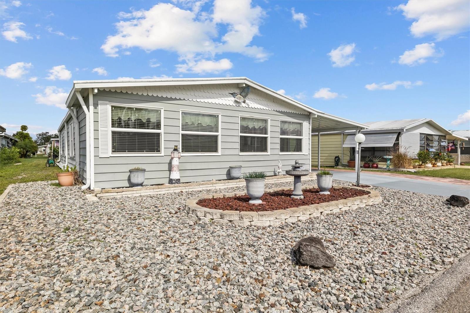 Welcome to this spacious very well maintained and updated double-wide manufactured home on OWNED land in the sought-after 55+ lakefront community of Lake n Golf Estates in Winter Haven. Offering a great floorplan and multiple living areas, this home combines modern updates with comfortable Florida living.
The chef's kitchen was fully updated just two years ago, featuring new countertops, stainless steel appliances, and refreshed cabinetry. Wonderful dining room with updated built-in cabinetry. Other major improvements include a full carport replacement 2 years ago, an AC unit installed in 2020, a main roof replaced about 2 years ago, and a new front Florida room with roof replaced approximately 8 years ago. Inside, you’ll find updated flooring, an inside laundry room, a front Florida room under central air and heat, and an additional side Florida room with wall AC unit, perfect for relaxing or entertaining. A spacious double workshop offers plenty of storage and hobby space or room to park the golf cart in the back workshop. This home comes partially furnished and even includes a golf cart!
Lake n Golf Estates provides the perfect amenities with a pool and spa, shuffleboard courts, clubhouse and community lake access and boat dock. Located near HWY 27, shopping, restaurants, and medical facilities, this community also offers low HOA fees of just $550 per year. Move-in ready and packed with value, this home is a must-see—schedule your private showing today!