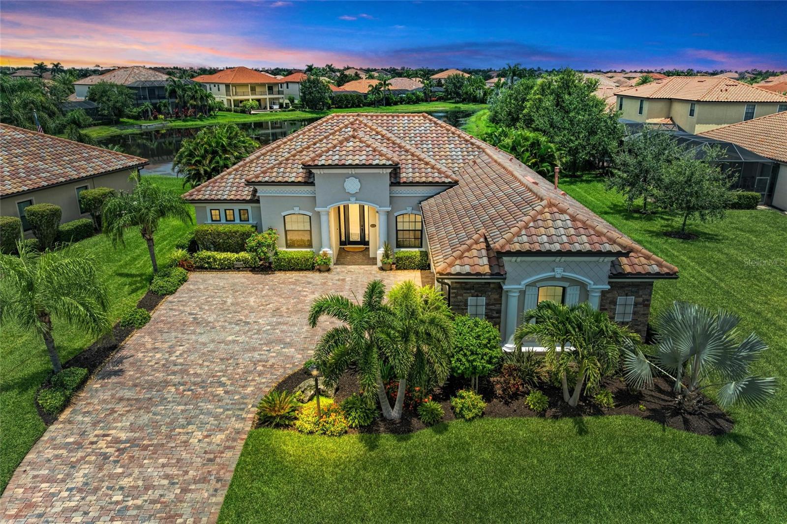 Welcome Home to your new beautifully customized lakefront pool home located in the prestigious, gated community of Bridgewater at Lakewood Ranch. This popular, Cambridge Estate Series model features 3 spacious bedrooms, 2.5 bathrooms, a 3-car garage, and a private study/office, offering the perfect combination of luxury, comfort, & design. With over $100,000 in designer upgrades, no detail has been overlooked in creating this refined & meticulously maintained residence. From the moment you arrive, you'll be captivated by the home’s remarkable curb appeal, enhanced by lush landscaping & a freshly painted exterior (2023). Inside, the open-concept layout is both elegant & inviting, featuring volume ceilings, 8-foot doors, crown molding, & custom feature walls in the great room, dining room, study/office & owner’s suite as well as wainscoting & bead board in the secondary bedrooms . The great room is a true showstopper, showcasing a coffered ceiling with wood trim, recessed lighting, a built-in entertainment console, glass shelving, accent lighting & equipped with a Motorized slider door shade—making it ideal for entertaining. The completely remodeled gourmet kitchen (2022) is a chef’s dream, outfitted with solid wood, soft-close cabinetry, Taj Mahal Quartzite countertops, an undermount 30” KRAUS stainless steel sink, MOEN motion-sensor faucet, custom lighting w/transom uplighting/under-cabinet LED downlighting, pop-up electrical outlets w/ built-in charging station & new GE stainless steel appliances. The formal dining room & private office, enhanced by French doors, add versatility & sophistication to the layout. All bathrooms were completely renovated in 2022, featuring Taj Mahal Quartzite counters, modern faucets fixtures, fresh paint, & a glass shower enclosure in the second bathroom. Additional interior highlights include custom Hunter Douglas window treatments throughout, with a motorized shade for the sliding glass door in the great room, a HALO whole-house water purification system, custom-designed closets in the primary suite, ceramic wood-look tile in the den & owner’s suite, & new LG front-load washer & dryer (2022). All smoke detectors were replaced in 2025. Outdoor living is equally impressive. The screened lanai offers updated lighting & ample space to enjoy the stunning lake views, sunrises, & tranquil Florida wildlife. The resort-style pool & spa create a peaceful oasis perfect for entertaining or unwinding at the end of the day. The home is equipped with HIGH-IMPACT HURRICANE RATED WINDOWS & a HIGH-IMPACT HURRICANE SCREENED ENCLOSURE. Bridgewater at Lakewood Ranch is a highly desirable, maintenance-free, gated community offering beautifully landscaped grounds, pavered driveways, a community park w/social events, & walking paths. With low HOA fees covering lawn care, reserves, & common area maintenance, residents enjoy peace of mind & convenience. Just minutes from top-rated schools including Lakewood Ranch Preparatory Academy, world-class golf courses, dining, shopping, University Town Center, & a short drive to the white-sand beaches, downtown Sarasota, & I-75 for quick access to Tampa, St. Petersburg, & beyond. This move-in ready, feature-rich home offers a rare opportunity to enjoy luxury living in the nation’s #1 top master-planned community. Whether you’re seeking refined design, modern upgrades, or the perfect Florida lifestyle, 5655 Cloverleaf Run delivers it all—and more.