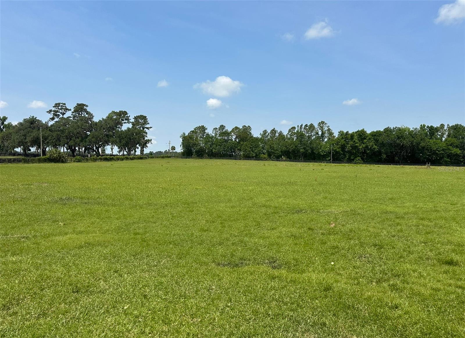 Nestled in one of Ocala/Marion County’s most coveted equestrian and farmland corridors, this 16.56-acre Class A-1 property offers an exceptional opportunity—rarely found in today’s market. Fronting NW 63rd Street just off the highly sought-after Highway 225 corridor, this exceptional property offers a unique opportunity for those looking to build a luxury estate, dream equestrian facility, or private farm residence. Ideally located only 8.3 miles from the renowned World Equestrian Center and just 7 miles from HITS Post Time Farm, the location is second to none for equine enthusiasts and those seeking a refined country lifestyle with easy access to amenities, shopping, and other services. The landscape is truly breathtaking, featuring a picturesque mix of oak hammocks and cleared pasture, along with an established well, power on site, and a charming pond that could easily be restored as a water feature. While existing structures are in disrepair and are likely a tear down, they have been assigned no value and promote a clean slate for development. Properties of this caliber, in such a prime location, are becoming increasingly rare—don’t miss the opportunity to make this stunning property your own!