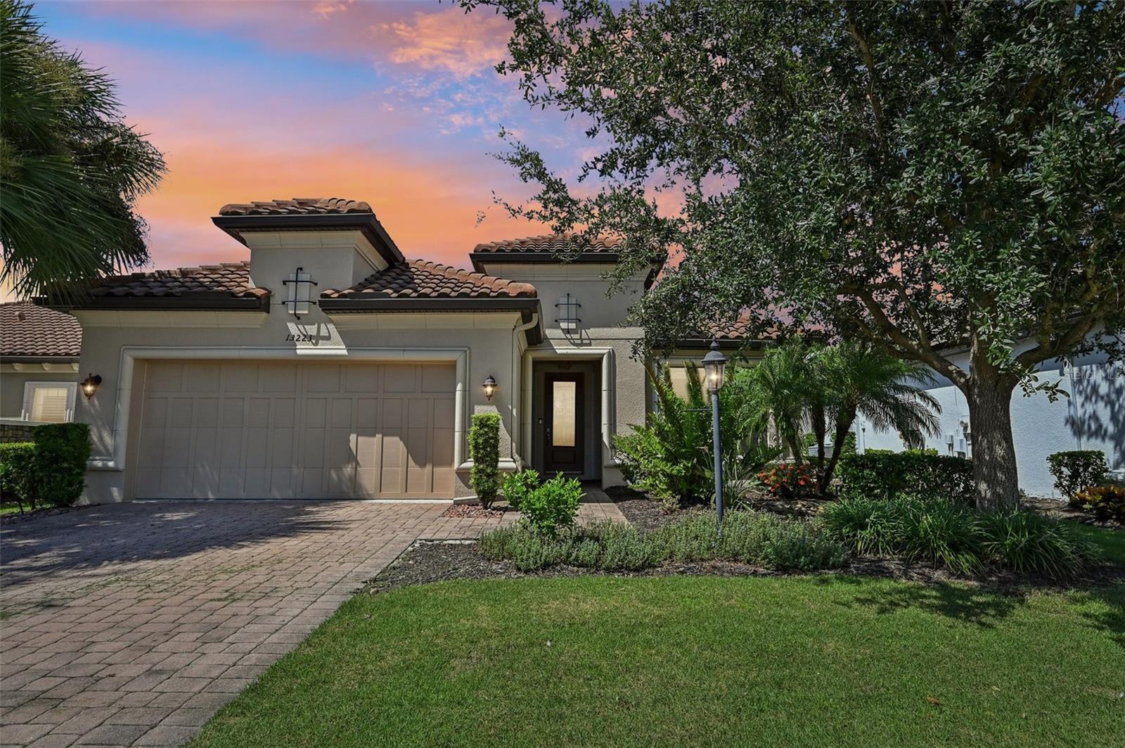 Come live the resort lifestyle in the highly desired Esplanade community. A sanctuary inside and out, this home welcomes you with a light filled open concept Lazio model design with engineered hardwood floors, designer light fixtures, tray ceilings and opulent crown molding throughout. The chef's kitchen boasts Monogram appliances, double ovens, pantry, touchless faucet, granite counters with a huge island for entertaining. The open living and dining areas are great to accommodate all your guests inside or you can open all the sliders to the screened extra large lanai. This 25 x 36 peaceful area is gorgeously landscaped and you can enjoy the serene waterfall of the koi pond and lush greenery. There is plenty of space for seating and access to the granite wet bar and full outdoor kitchen with stainless cabinets, grill, sink and refrigerator. The owner's suite is equipped with a large closet with custom built ins, an expanded size shower with seat, and double sinks over granite marble counter. Two other full baths with granite counters and fine finishes are adjacent to the two other nicely sized bedrooms. Additionally there is also a 11x13 bonus room/office/den behind frosted glass doors offering great flexibility. A full laundry room with plenty of cabinets and counter space is right off the 2 car garage. At the end of the street you have tennis courts, pickleball, waterfront park and large pool; with 2 additional pools, fitness center, golf club, spa, nail salon, dog parks, and restaurants just a short walk away in the community. There is no need to pay more for a deeded golf membership when all residents can use the amenities for just a fee. Explore all the benefits at the community website, esplanadelwr. Whether you are going to out of the town to the Waterside district, Sarasota's wealth of cultural highlights, or a lazy day at the nearby beaches of Anna Maria or Siesta Key, there is something here for everyone.