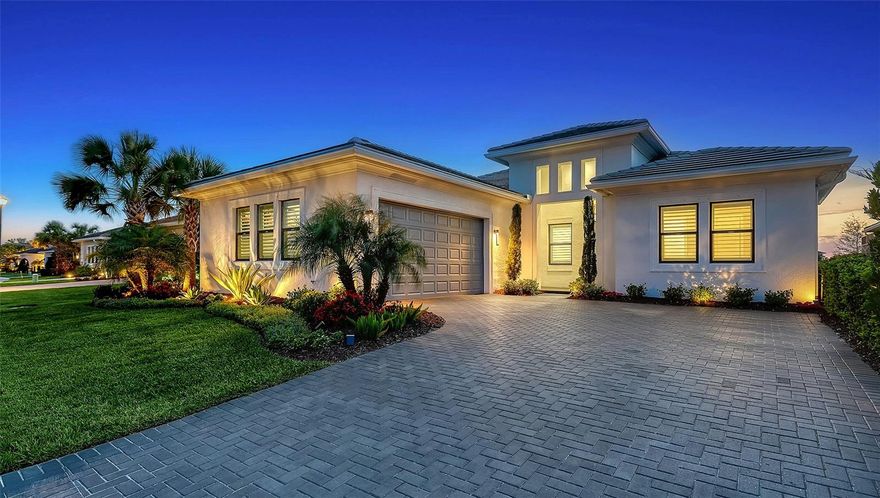 Positioned on one of the most coveted lakefront homesites within Artistry Sarasota, this impeccably enhanced Monet residence embodies a refined, tranquil lifestyle with a thoughtful balance of privacy, elegance, and modern comfort. Lush, mature landscaping lines both sides of the backyard, creating a secluded sanctuary while preserving sweeping water views and generous space for a future pool—an ideal backdrop for quiet mornings and effortless outdoor living.  The residence offers a sophisticated and functional layout with three ensuite bedrooms, a dedicated den, and a well-appointed powder room for guests. The primary suite with wood effect Porcelain tile flooring is a serene retreat, oriented to capture long lake vistas and soft natural light enhancing the home’s calming atmosphere.  Inside, the interiors present a crisp, luminous aesthetic complemented by carefully curated upgrades, including large format high gloss tile. The great room is anchored by a custom-designed fireplace feature, framed by solid white oak built-in shelving and cabinetry with integrated lighting—delivering both architectural presence and warmth. Over $130,000 in builder and owner enhancements elevate the home throughout, including whole-house plantation shutters, bespoke drapery, custom office built-ins, and a redesigned laundry room with added cabinetry and workspace.  Further refinements include large-format polished tile flooring across the main living areas, quartz surfaces in the kitchen, soft-close cabinetry with crown detailing, designer lighting, and spa-inspired bathrooms with tile extending to the ceiling. The outdoor living experience is equally considered, with a screened patio enclosure, professionally reimagined landscaping, and sealed paver driveway completing the home’s polished presentation.  As one of the most extensively upgraded Monet residences currently available, this property offers a rare level of completion and move-in readiness within the community.  Residents of Artistry Sarasota enjoy a gated, maintenance-free environment complemented by resort-style amenities, including a clubhouse, pool, pickleball and basketball courts, playground, and scenic walking trails. With no CDD fees and a location outside of a flood zone, the home also provides peace of mind.  Ideally situated, this residence offers convenient access to The Mall at University Town Center, championship golf courses, acclaimed dining, and the renowned cultural and waterfront destinations of Sarasota—including its world-class beaches and vibrant arts scene.  Furnishings may be available separately.