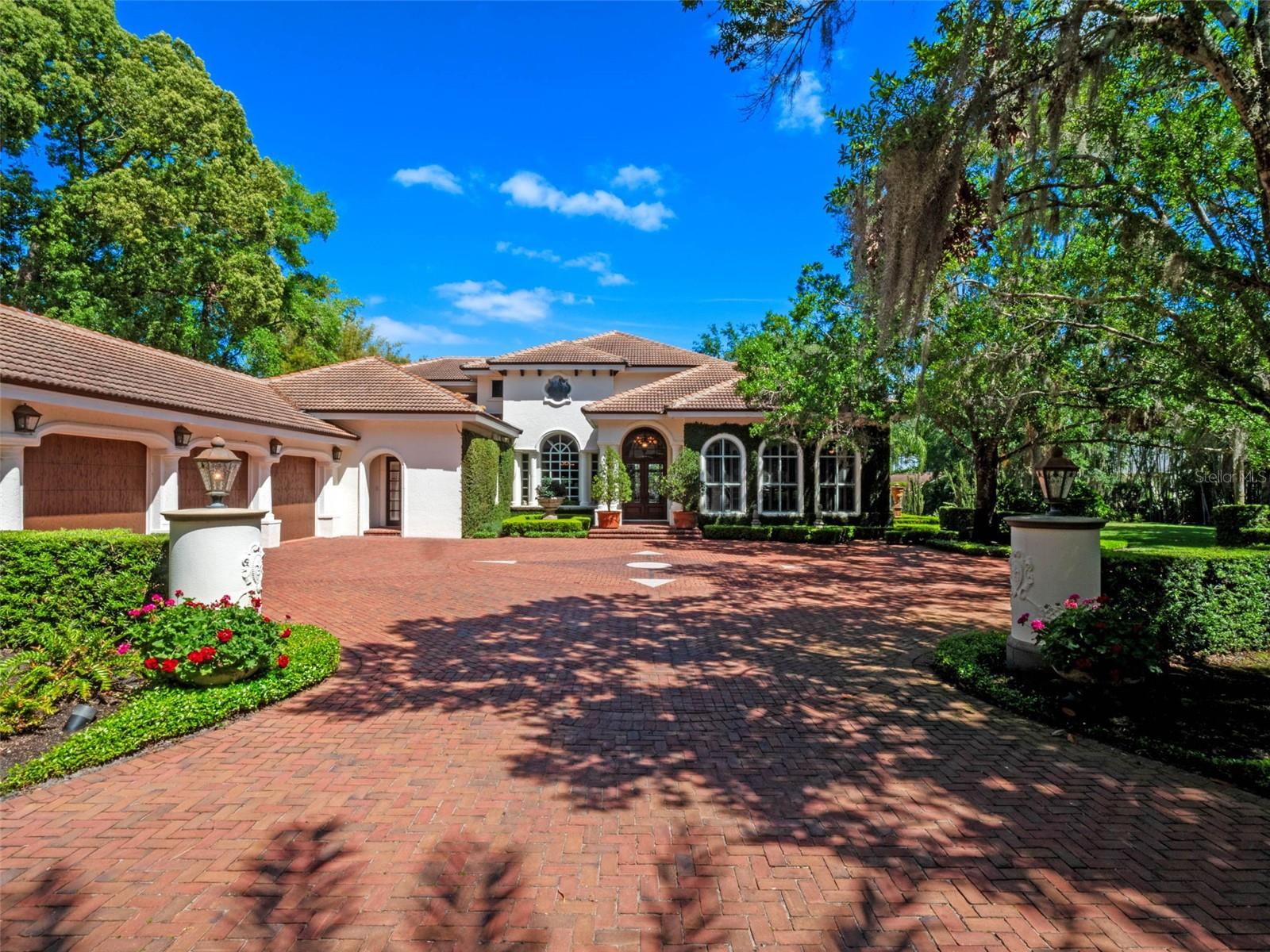 Discover an extraordinary lifestyle at this one-of-a-kind estate, elegantly situated on the shores of Lake Maitland in the distinguished Winter Park area. This remarkable property is unlike any other in the market, seamlessly blending sophisticated Mediterranean and Spanish architectural elements to create a serene and inviting retreat. Upon entering through the stately steel gates, you are welcomed by a picturesque, tree-lined driveway that leads to a formal motor court, enveloped in lush, mature landscaping that ensures complete privacy. Spanning an expansive 2.10 acres with an impressive 217 feet of lake frontage, this estate offers a breathtaking park-like setting that is perfect for both relaxation and vibrant entertaining. The primary residence encompasses six generously sized bedrooms and 6.5 luxurious baths, featuring exquisite traditional custom details and an abundance of elegant living space. Outside, indulge in the stunning waterside rose garden and pavilion, alongside an expansive pool designed for year-round enjoyment and perfect for hosting guests. This estate also boasts a delightful gatehouse, which includes a one-bedroom, one-bath suite and a dedicated two-car garage, providing an ideal retreat for visitors. Additionally, a separate lake house, constructed in 2004, features richly hued wooden vaulted ceilings, a cozy stone fireplace, and a generously sized covered porch that spans the length of the home showcasing spectacular views of the water and gardens. This property transcends the notion of a mere home; it embodies a truly unique lifestyle. Whether you desire serene lakeside tranquility or a sumptuous entertainer's haven, this exceptional offering presents an unmatched opportunity to own a slice of paradise in Winter Park. As you step through the grand double-door entry of the main residence, you are enveloped in elegance and comfort. This thoughtfully designed home balances functionality with style, featuring dual office suites, a game room, and ample storage space throughout, catering to the demands of modern living. The awe-inspiring 22.5-foot ceilings in the grand foyer and dining room create an impressive ambiance, illuminated by uniquely designed windows that flood the space with natural light. The smartly designed floor plan ensures both privacy and convenience, with the primary suite thoughtfully positioned in a secluded area of the home, while an additional main-level bedroom provides flexibility for guests or family. The expansive kitchen is a culinary dream, boasting a spacious island, breakfast bar, a walk-in pantry, and a gas cook range, all seamlessly connected to a cozy dinette area. Upstairs, you’ll find four additional bedrooms and three beautifully renovated bathrooms that prioritize comfort and space. Step outside to an oversized screened and covered lanai, complete with multiple skylights that invite the beauty of the outdoors inside, perfect for relaxation or entertaining. Enjoy captivating views of the pool area, rose garden with Tea House, and tranquil lake, creating an idyllic backdrop for both peaceful moments and lively gatherings. This main residence is a sophisticated blend of luxury and practicality, designed for those who truly appreciate the finer things in life. Don’t miss this rare opportunity to claim this stunning residence as your own—schedule a private showing today to experience the unparalleled elegance and uniqueness of this extraordinary estate!