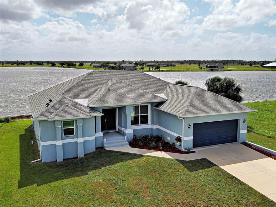 What a view! Welcome to your stunning lake view home! This custom built 3 bed 2 bath Walker home constructed in 2020 has elevated stem walls and serene water views from every room. A chef’s kitchen sets the stage with a 10-foot island, high-end soft-close cabinetry with extra storage under the island, a vented hood, stainless steel appliances, and quartz countertops. Elegant in style, a solid quartz backsplash continues from the kitchen counters towards the ceiling. Water views from the kitchen, too? Absolutely! 
Porcelain tile flooring throughout with a split floor plan for additional privacy for family and/or guests. Coffered ceilings in the great room and master bedroom lends extra detail and class. The master bedroom has 2, large walk-in closets, a beautiful bathroom, and sliding glass door with access to the lanai. Both bathrooms feature tiled walk-in showers, plus a standalone bidet in bathroom 2. Bedroom 3 has a built-in Murphy bed as an option for an office or additional sleeping space. Hurricane impact-resistant  windows and doors throughout the home for extra safety and security, plus storm shutters to protect outdoor space, saving on insurance premiums. The 19 foot pavered lanai is enclosed with Super Screen, features an outdoor kitchen with wet bar and has views to die for! The extended garage has an entry ramp for easy access. 
The home has public water and sewer, irrigation, underground electric with a full house 50 AMP generator plug-in and new roof in 2023. The location is perfect for those who desire privacy with nature views, as well as being close to world-class beaches, fishing and multiple airports. Schedule your private viewing today.