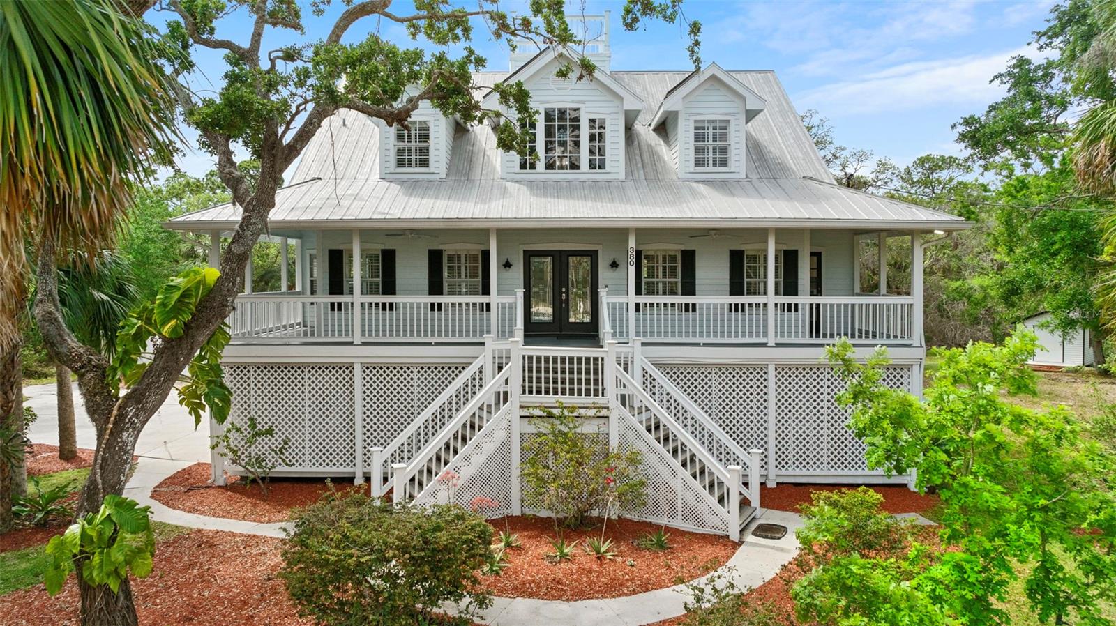 PRICE REDUCTION! Now priced below value, this is your chance to own this incredible Key West style pool home on an oversized conservation lot in highly desirable Oldsmar. Located on a cul de sac with no through traffic on nearly an acre of land, with lush tropical landscaping backing up to forested conservation for added privacy. At the main entry is an inviting wraparound porch. Step inside the welcoming foyer to a soaring vaulted ceiling in the great room, which also features a wood burning fireplace and two sets of French doors leading to screened back porches and beyond to a huge rear deck that spans the length of the house and overlooks the large free form pool and spa. The primary suite has two walk-in closets and a remodeled bathroom (2023) with two vanities, a whirlpool tub, tiled walk-in shower, and water closet. The remodeled gourmet kitchen (2022) features stainless steel appliances, Viking dual fuel range with pot filler and vent hood, quartz counters, plentiful cabinetry, and a large island with wine fridge and copper top (durable and naturally anti-microbial/anti-bacterial). Off the kitchen is a half bathroom, a laundry room with utility sink and extra pantry storage, and a wet bar/coffee nook with even more pantry storage. Upstairs are two spacious bedrooms, a loft/office area, and updated hall bathroom (2023). At the top of the house is a railed rooftop platform offering stunning views out to Tampa Bay. The ground floor features covered parking for at least 4 vehicles, spacious storage/workshop areas, and a garage apartment/in-law suite with a bedroom, living/game room, kitchenette, and full bathroom. The circular driveway, side driveway, and large parking pad provide abundant parking for guests, boats, RV, etc. No HOA or CDD. Oldsmar is a waterfront golf cart community known for wonderful parks, quality of life, A rated schools, and convenient access to Tampa International Airport, Gulf beaches, shopping, dining, and more. Schedule your private showing today! As an added bonus, the seller has an assumable government loan at just 2.75%! Call agent for details.