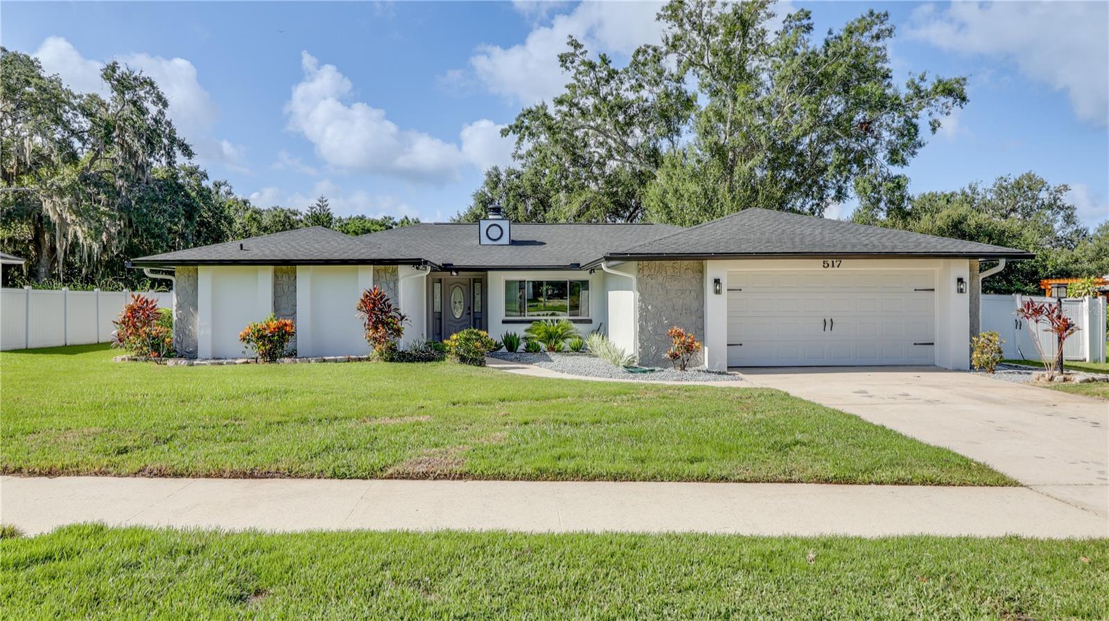 Welcome to 517 Garden Heights Drive — a fully renovated 4-bedroom, 2-bath modern farmhouse on a spacious 0.33-acre lot in the highly desirable golf cart district of Winter Garden. Just one mile from the vibrant Plant Street district and offering Lake Apopka views from the driveway, this home delivers the perfect blend of lifestyle and long-term value. Key updates include a brand-new roof (installed July 2025), a newer HVAC system (2021), and a new water heater (2025) — providing essential peace of mind from day one. With the ongoing upturn in the Winter Garden real estate market, this property also represents a smart investment opportunity in one of Central Florida’s most thriving communities.
Step inside to discover nearly 2,000 square feet of carefully curated living space with all-new tile flooring, fresh paint, updated texture, and modern wood paneling accents. The open-concept layout features a striking shiplap fireplace, brand-new ceiling fans and lighting fixtures throughout, and a showstopping kitchen designed for both function and flair — complete with quartz countertops, shaker cabinetry, gold hardware, stainless steel appliances, and stylish pendant lighting. Both bathrooms have been thoughtfully redesigned with custom tile work, dual vanities, and designer finishes, while the spacious primary suite includes a sliding barn door and spa-style bath.
Enjoy seamless indoor-outdoor living with a fully screened-in porch and outdoor wet bar, ideal for entertaining or relaxing with a view of your expansive backyard. A detached shed offers convenient storage, and the 2-car garage adds practical convenience. Best of all? No HOA. This move-in ready home checks all the boxes with thoughtful upgrades, timeless style, and an unbeatable location — the perfect place to live, enjoy, and grow equity for years to come.