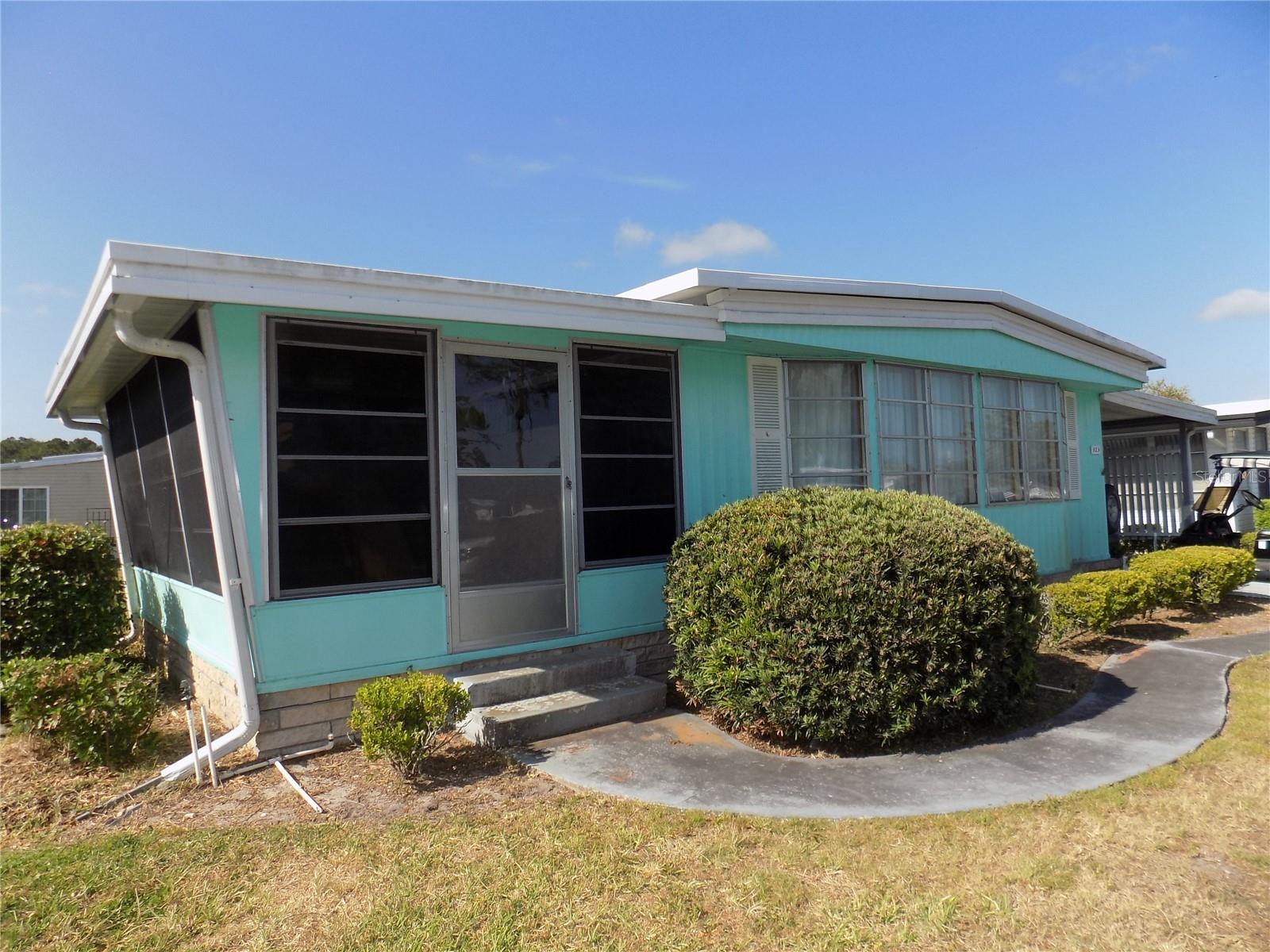 Roomy and open residence in an active, resident owned 55+ community. This home is perfect for the renovation enthusiast, with open living room adjacent to dining area with built in cabinets and shelving. Panoramic windows for beautiful Florida views. Attached screened porch with room for evening board games and outdoor dining. The ample kitchen has abundant countertop space and cabinet storage. Electric range and dishwasher. A closet pantry will complete your kitchen ensemble. 2 bedrooms with closet storage. Primary bedroom has ensuite bathroom and walk in closet. The affordable monthly maintenance fee of $346 includes water, sewer, lawn mowing, private emergency services and storage space for recreational vehicles, trailers and boats. Card rooms, craft room, billiard room, fitness center, library are some of the many amenities, as well as a full time program coordinator and over 100 different activities. This waterfront community has excellent fishing with a private marina with over 120 boat slips with access to the Harris Chain of Lakes. *Equal Opportunity Housing.*