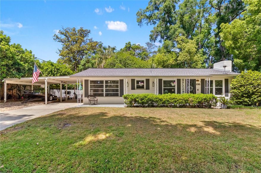 -CHARMING FISHER PARK- Welcome to 2312 SE 9th Terrace located in southeast Ocala just steps away from beautiful Fisher Park! Enjoy a meticulously-kept concrete block home sitting high on a hill situated on a quiet one-way street. This property offers modern conveniences, yet exudes mid-century character. The covered front porch is a lovely spot to sip coffee in the mornings and is just one of many outdoor spaces for entertaining and relaxing here. Step inside on to LVP floors- the flooring runs through the entire home, no carpet to fuss over. The living room is an open-concept space featuring a brick wood burning fireplace (that can easily be converted to gas if preferred), and newer windows allowing lovely natural light to pour in. The living space flows into the updated kitchen. The 8x4 hard surface kitchen counter is the perfect spot to pull up a few chairs and dine. White cabinetry, stainless steel appliances, and maximizing storage space was a top priority during this remodel. Two good-sized bedrooms share a full bathroom with tub shower combo. Bedroom 1 can comfortably fit a King-sized bed and dresser. The second bedroom is home to a daybed currently; both bedrooms with wide closets for more storage. Just off of the kitchen is a second living space/ BONUS room measuring 17x11 feet with ceiling fan. Make this a third bedroom; or, an amazing office, playroom, or second living room in your home! The laundry room with washer/ dryer to convey, plus a half bath with utility sink, just off of the BONUS room. Outdoors- there is just so much to share: covered parking to the left of your home, plus a beautiful covered entertainer's space sitting on new pavers- is the place to be! Set up your outdoor furniture on the 19x17 patio with metal roof. Need more storage? Enjoy the detached concrete block workshop with electric, and an additional aluminum shed on property. The backyard is fenced for your pets; NO HOA; NO Deed Restrictions; NOT in a flood zone per recent seller paperwork; in fact, owners are not required to carry flood insurance on this property. Major Updates Include: ROOF (2020); Rheem HVAC (2020), Rheem Water Heater (2020); 200-amp Cutler-Hammer Electrical Panel; Outdoor Covered Patio (2008); Subpanel for Generator; Honeywell wired security system. City of Ocala, public water and sewer. Fisher Park is a 5.14 acre park located within the City of Ocala offering sidewalks, a basketball court, bbq grills, exercise and playground equipment, and picnic tables for your enjoyment. St. John and Cornerstone Schools located just outside of the neighborhood and public school zoning includes Osceola Middle and Forest High Schools. Spend your days relaxing at the Park!