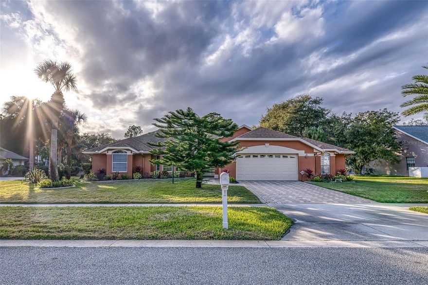 Welcome to this beautifully maintained single-story home offering one of the largest residential pools in Port Orange—an impressive 44’ x 22’, set on a generously sized .45-acre lot with peaceful wooded views and classic Florida charm. A unique 16’ x 13’ workshop is conveniently located within the garage, featuring both interior access and exterior French doors—ideal for hobbies, storage, or creative space.

From the moment you arrive, mature palms, lush landscaping, and strong curb appeal create a warm and inviting first impression. Inside, the home opens to a bright and spacious living area with vaulted ceilings, ceiling fans, and rich laminate wood flooring throughout the main living spaces. The open-concept layout allows the living and dining areas to flow seamlessly into the kitchen, making the home perfect for everyday living and entertaining. Large windows and sliding glass doors flood the space with natural light and provide easy access to the outdoor living areas.

The centrally located kitchen offers ample cabinetry, generous counter space, and a casual breakfast nook, ideal for morning coffee or informal meals while staying connected to the main living areas.

The expansive primary suite (22’ x 13’) serves as a comfortable retreat with abundant natural light and an en-suite bathroom featuring dual vanities, generous storage, and a walk-in shower. Additional bedrooms are well-sized and versatile—perfect for guests, a home office, or hobby space—while secondary bathrooms offer clean, classic finishes and functional layouts.

Step outside to your private screened-in pool oasis, designed for year-round enjoyment and featuring a full cabana bathroom, a rare and highly desirable feature at this price point. The expansive pool deck provides ample space for lounging, dining, and entertaining, while the screen enclosure adds comfort and peace of mind. A covered lanai extends the living space outdoors and overlooks the serene backyard—an ideal setting for gatherings or quiet evenings.

With NO HOA, a thoughtful layout, generous indoor and outdoor living areas, and tranquil surroundings, this home offers an exceptional blend of comfort, functionality, and Florida lifestyle living. Conveniently located near shopping, dining, and everyday amenities, the property is ready to enjoy as-is or personalize to suit your vision.