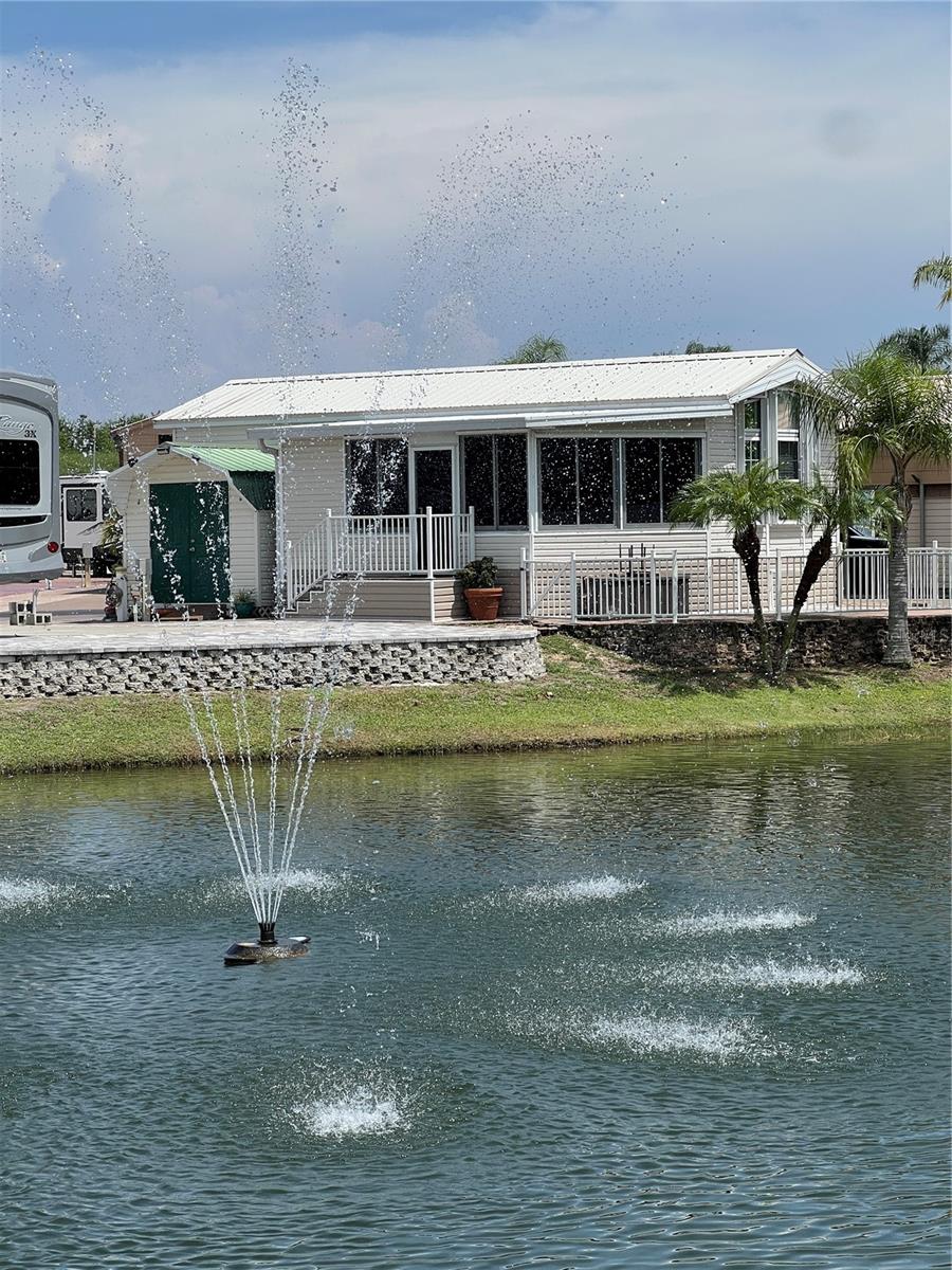 ~Big O RV Resort~55+. Active Lifestyles in a gated community, One owner custom made Chariot Park model with a custom Sunroom (Hurricane wind rated) by one of the best builders around the lake! 1B 1.5 Baths (Could be a 2 bedroom) Located on a lake with a water view w/ a fountain! Tastefully furnished & flooring by Jeanettes Interiors. Custom Blinds & all windows are tinted. 8X8 Wooly shed w/ electric & AC. Gorgeous patio fenced in for your fur baby overlooking the water. Custom Hurricane shutters. Pavers & steps to water. Nice glass front storm door. Wired for a generator. Bring the hubby & boat for good times! New casino 25 minutes away- shopping and restaurants nearby. Boat ramp in the park. Heated pool,
