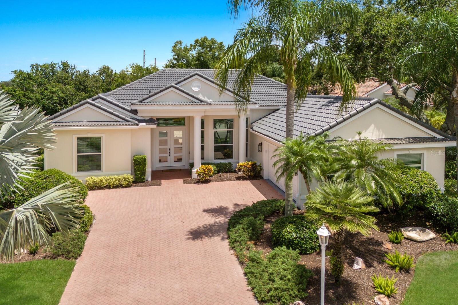 Welcome to this completely reimagined home in University Park Country Club. Originally crafted by builder Todd Johnson, it just underwent a meticulous renovation including all new impact resistant windows and doors. This spacious residence boasts 4 bedrooms and 3 full bathrooms. From the moment you enter through the double doors you are welcomed with soaring high ceilings providing a naturally lit atmosphere throughout the home. The reconfigured Kitchen is the center point of the home and truly a chef’s dream. The large island offers lots of counter space to prepare and host food for family and guests. The perimeter is finished with custom cabinets, a gas cooktop, and a built-in Refrigerator. Enjoy morning coffee in the breakfast nook that features a large aquarium window providing unobstructed views of the outdoor space, sparkling pool, and lush landscaping as the backdrop. The large family room features an oversized fireplace creating a warm environment to host endless family and friend’s gatherings.
The split plan ensures privacy to both family members or guests with 3 bedrooms and 2 full bathrooms situated on one side and the spacious primary suite occupying the opposite wing. The primary suite features a spa like setting with a large walk-in shower, standing soaking tub, dual vanities with makeup counter, private water closet and a generous walk-in closet. Step outdoors onto the covered lanai and enjoy the outdoor space right from your private suite. Large sliders in the main living spaces open to the outdoor space where you are greeted by a pool, spa, and outdoor kitchen, offering a seamless extension to the coveted indoor/outdoor living. The home also includes a generous sized laundry/utility room that leads to an oversized side-entry 2-car garage, featuring a convenient separate door for golf cart access. University Park Country Club is a highly ranked Florida golf course featuring 27 holes of championship golf; tennis and pickleball; fitness center and many social and group activities. Just a quick drive to downtown Sarasota and you will be transformed from the peaceful private setting of UPCC to fine dining, arts & theatres, entertainment, and world-class beaches. With SRQ International Airport nearby and I-75 easily accessible, convenience is at your fingertips. Located just outside the gates is University Town Center with hundreds of nationally known and local shops, restaurants and attractions including Mote Marine Aquarium, Tiger Woods backed Pop Stroke, Nathan Benderson Rowing, and countless other attractions. A minimum social membership is required at UPCC, a residents owned Recreation District.