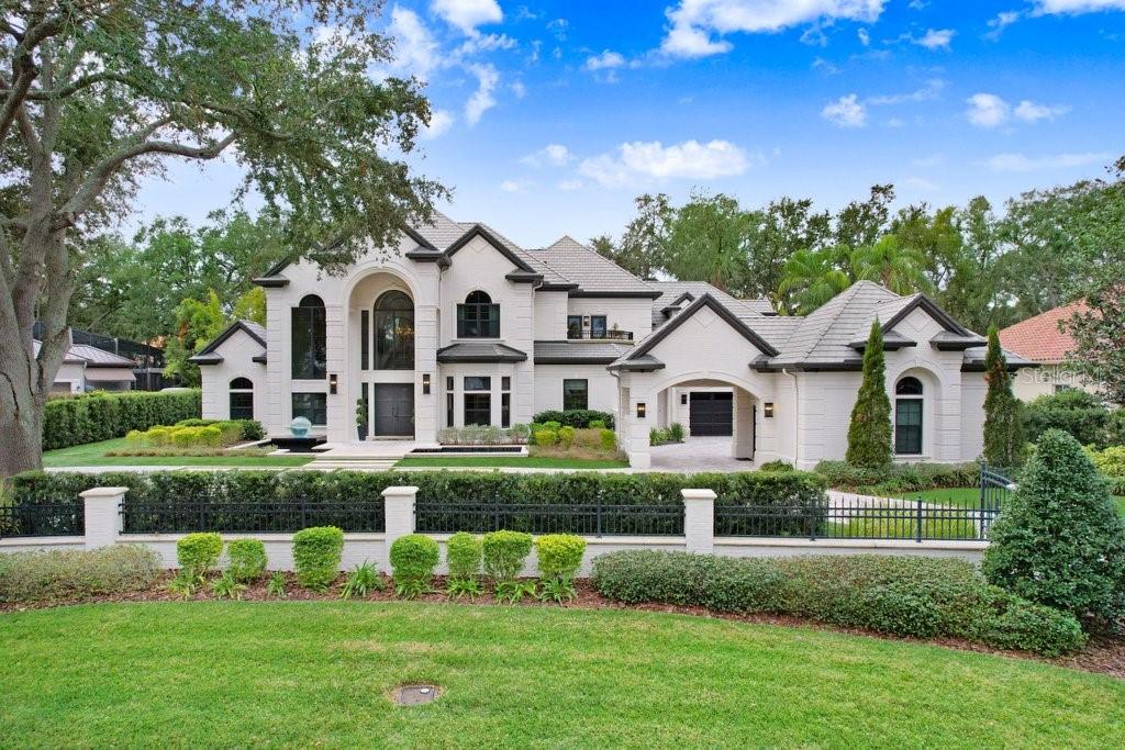 Experience the epitome of luxury nestled inside the prestigious gated Avila Community. This exquisitely updated residence boasts an array of custom features, starting with a breathtaking entrance that leads you over a serene reflection pool featuring a striking glass sphere fountain. As you step through the handcrafted steel doors, you're welcomed by a dynamic two-story foyer featuring a stunning curved stairwell, floor to ceiling millwork, and handcrafted crystal chandeliers setting the stage for the exquisite craftsmanship found throughout the home. The formal living room offers panoramic views of your backyard paradise, highlighted by a two-story fireplace with marble insert that serves as a captivating centerpiece. The formal dining room exudes sophistication with its grasscloth wall coverings, bespoke chandelier, and dynamic cove lighting. Connect seamlessly to the gourmet kitchen through a custom wet bar. The kitchen is equipped with Thermadore Pro-line appliances, including a wine fridge, gas range with a separate steaming oven. The oversized marble top island is perfect for meal prep and bar seating, while featuring a 45-inch stainless steel Galley sink. The casual dining area offers a bright space to enjoy everyday meals. The family room invites you to unwind with its stunning book-matched marble feature wall, electric fireplace and lighted coves. The game room offers a full pool bath, generous custom storage, millwork and exotic marble counters creating an inviting space for leisure. Retreat to the master suite, complete with elegant wall coverings and a cozy sitting area. The master en suite bathroom is a spa-like experience featuring oversized soaking tub, rainfall shower with programmable body jets, all fully encased by book-matched marble slabs. Dual walk-in closets with lighted cabinetry provide ample space for all your storage needs. The laundry room is well-equipped with two sets of Electrolux washers and dryers, expansive marble countertops, double height cabinetry and a dog wash station. Also found on the main floor is an office and beautiful powder bath. The upper level features 5 guest bedrooms with one serving as an additional master suite. The three guest bathrooms all have marble counters, while two of them have full marble feature wall mosaics with brass inlay. Step outside to your award-winning outdoor sanctuary, designed by renowned pool architect Ryan Hughes. The covered lanai features stained hardwood ceilings, luxurious outdoor furniture, and a full dining area. Enjoy a custom-built outdoor kitchen complete with a Black Diamond grill, hibachi flattop, and electric pizza oven. The outdoor space is a true oasis, with a resort-style fully tiled pool, infinity edge spa, sunken fire pit area featuring an acrylic underwater viewing panel. This outdoor retreat is enhanced by marble decking and breathtaking water features, including multiple waterfalls and a serene koi pond with a complete turf yard and a putting green. The entire property is encircled by a privacy wall, and multi camera security system enhanced by automatic gates flanking each side of the circular driveway. Detached in-law suite fully remodeled.. The garage has ample storage for vehicles or other belongings. Additional Features include smart home systems and high-impact windows. The exceptional blend of modern comfort and timeless elegance has been meticulously designed to capture the beauty of its surroundings while providing unparalleled luxury.