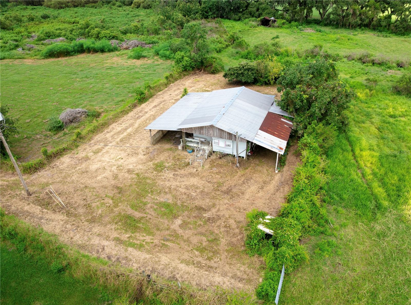 Situated in North Plant City, this 37.395-acre property features approximately 11-12 acres of uplands and 26.64 acres of lowlands. A well-maintained pole barn with a concrete slab and shed. 1978 singlewide mobile home with two bedrooms and two baths, provides added value. With well, power and septic systems already installed, future development could benefit from significant savings on impact fees and utility costs. With the, existing structures, and ready utilities, this property presents a rare opportunity for development or retreat in a peaceful North Plant City setting. Surveys Available upon request.