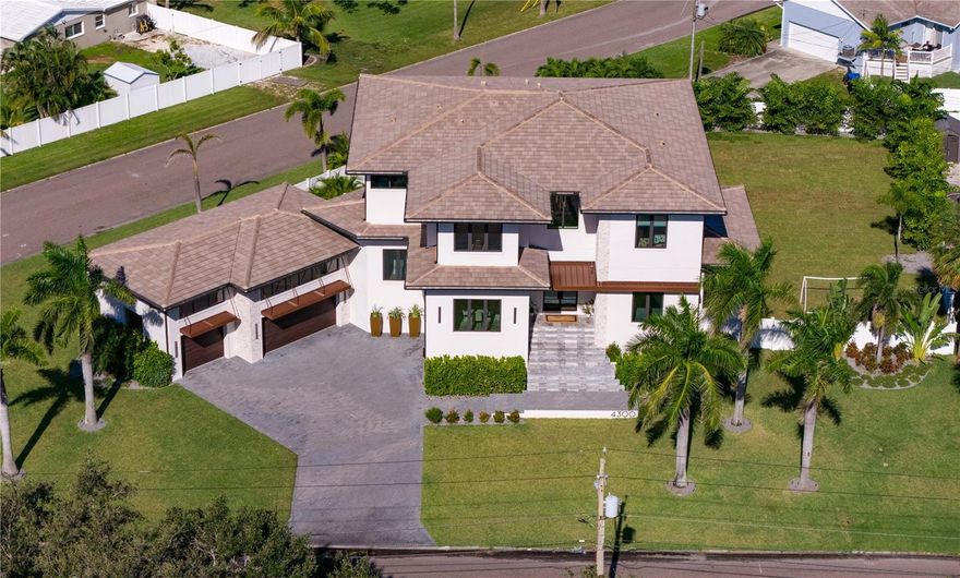 Welcome home to this Transitional Modern inspired luxury residence, nestled on a tremendous 1/2 ACRE lot, on prestigious Bayshore Blvd. No detail was missed, and no expense spared in the design and construction of this home. Step through the high-end front doors into a large foyer with 22' ceilings. The formal dining room features a custom glass wine cellar. You'll love the custom chef's kitchen with a full Thermador appliance package and gas cooktop. Step through to a very spacious butler's pantry and walk-in food pantry.  The family room features a signature fireplace and plenty of space for everyone.  Light pours through the IMPACT WINDOWS AND DOORS, out to a gorgeous lanai with Artisan outdoor kitchen area. The pool and spa are salt water and heated, plus the HUGE BACKYARD is big enough to easily host a wedding. A RARE FIND is the SIX EN SUITE BEDROOMS this home features, with a FIRST FLOOR BONUS ROOM. The first floor also features an en suite guest bedroom, a dedicated office, living room, first-floor laundry, and features 12-FOOT CEILINGS. Upstairs you are treated to a primary suite with sitting room (with some water views), a drop-dead spa-like bathroom, and elegant walk-in closet with a dressing island. A second laundry room plus four spacious and comfortable guest en suite bedrooms round out the second floor, all with walk-in closets, and all with 10-foot ceilings. Some of the impressive construction and convenience highlights include: concrete TILE ROOF, WHOLE-HOUSE GENERATOR, spray foam insulation, electric car charging, large AV closet with addiitonal storage, WOOD FLOORS THROUGHOUT, built-in exterior perimeter lighting, casement windows (impact), Culligan water softening system, outdoor shower.