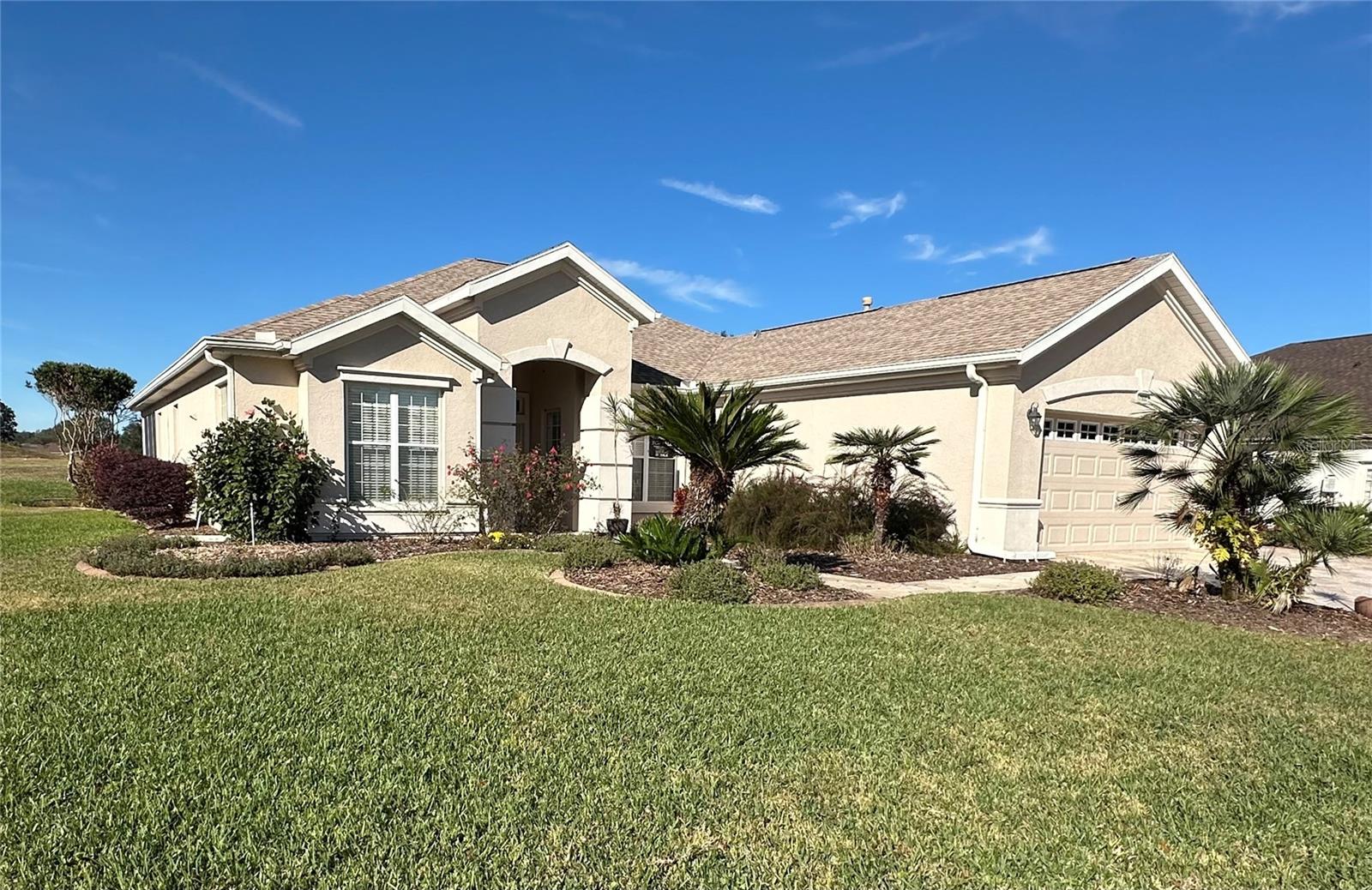 This immaculate 3-bedroom, 2-bath Santa Rosa model in Del Webb Spruce Creek Golf & Country Club (55+), Summerfield, FL, offers stunning views of the 15th tee from its expanded, enclosed, air-conditioned lanai—ideal for relaxing or entertaining. Featuring an open floor plan with high ceilings, designer window treatments, and an updated kitchen with solid wood cabinets, granite counter tops, built-in desk, and updated stainless steel appliances, the interior exudes comfort and style. The versatile third bedroom serves as an office or guest room with a full closet, while the spacious master suite showcases new flooring and large bay windows overlooking the golf course. Recent upgrades include all new luxury vinyl flooring (2024), a new roof (2023), air conditioning (2018), and a resurfaced driveway (2020), complemented by mature landscaping and an oversized lot in the Torrey Pines area. The spacious two-car plus golf cart garage provides additional power and storage for two golf carts, and residents enjoy exclusive access to parks, pools, tennis, pickleball, clubs, dining, and entertainment, all within a secure, gated community with a low monthly amenity fee and no CDD or bond. Secure Gated Community just south of Ocala with shopping and entertainment nearby in The Villages and the Eagle Ridge Golf Club has four 9 hole courses.