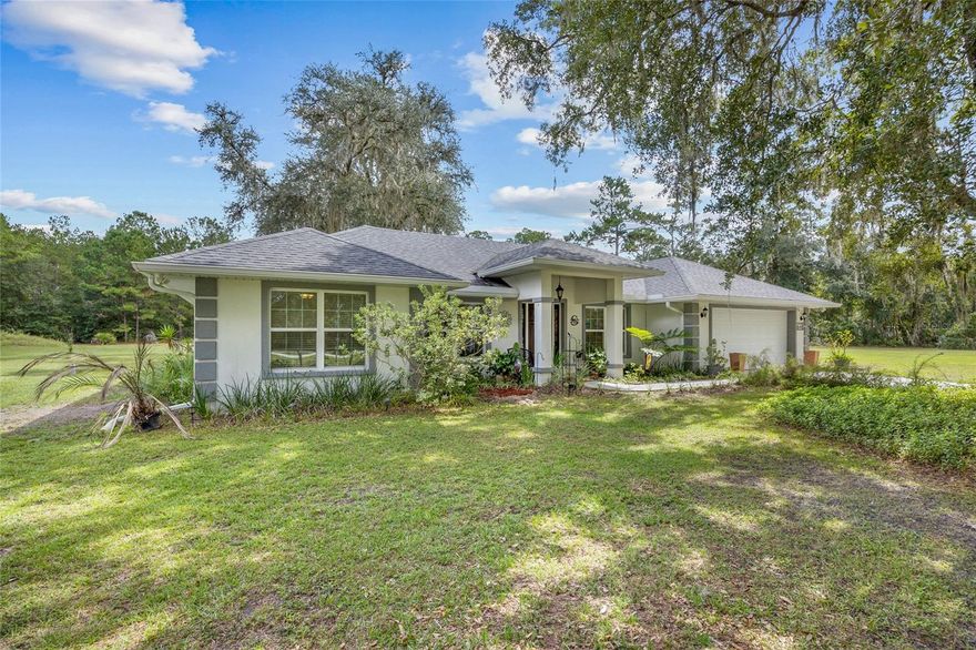 Forget the headaches and timelines of new construction—this gorgeous 2019 home is like new and perfectly situated on a sprawling 5-acre lot zoned for horses!  The property has 282.66 feet of road frontage to County Road 234, evoking a peaceful, rural setting with natural beauty and agricultural charm. The approach to the home is defined by an exquisite front porch featuring a wood-look tiled landing, stately overhang, and elegant pillars, all illuminated by a classic hanging light.  Stepping inside, you’ll find 1,944 sq ft of beautifully appointed living space boasting wood-look tile, vaulted ceilings, bespoke architectural details, and spacious rooms within a layout that feels intuitively designed for modern living.  To the left of the welcoming foyer is the formal living room.  The formal dining room is to the right.  The light and airy family room opens seamlessly to the impeccably equipped granite-clad kitchen with stainless steel appliances, breakfast bar, and breakfast nook.  This 3-bed, 2-bath home features a split-bedroom plan, positioning the primary suite off the kitchen.  Designed to pamper and restore, the bedroom includes a large walk-in closet and ensuite with double vanities, soaking tub, walk-in shower, water closet, and high-end finishes.  The home’s remaining two bedrooms and dedicated guest bath create a private wing where family members and visitors can enjoy their own luxurious haven off the living room.  You’ll also find a laundry room, and delightful screened-in porch that leads out to a patio.  Additional highlights include a security system, water softener system, sidewalks, and an attached two-car garage providing convenience and additional storage.  The acreage is perimeter-fenced, providing a boundary, but the fence will require repairs or replacement in some areas.  Blending the best of both worlds, the picturesque tranquility of this countryside retreat is only 12 miles from Gainesville’s amenities and the vibrant energy of the University of Florida. The Gainesville Regional Airport is just 8 miles away.  Located 3.5 miles away is the Owen-Illinois Park at Windsor boat ramp, which provides a public boat launch with a dock, playground, recreational facilities, and parking on Newnans Lake.  This is a rare opportunity to own a recently-built home that offers privacy and freedom:  no HOA and plenty of land for homesteading, caring for animals, raising bees, and enjoying outdoor activities on a nature-based retreat.  Don't miss your chance to make this exceptional property your own!