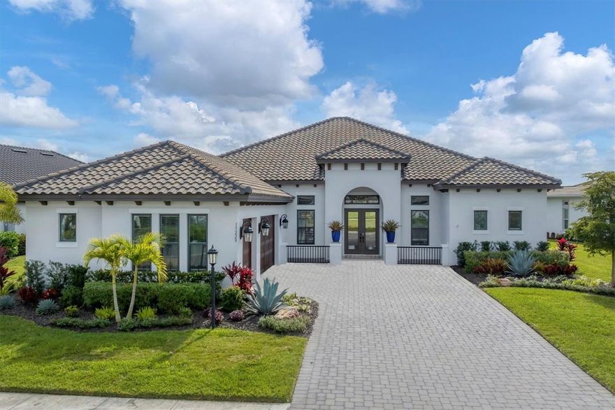 This stunning residence will impress the most discerning buyers with numerous custom upgrades and unobstructed lake and golf views. The large golf deeded lot has the ideal south facing lanai overlooking the 16th green. Located in the highly desirable Esplanade at Azario in Lakewood Ranch, this very popular and no longer available to build Beacon floor plan is designed to create the perfect space for indoor-outdoor living and entertaining. As you approach the glass front entry doors, you will be drawn inside by the light and bright open floor plan and the first glimpses of the breathtaking outdoors beyond. You will quickly notice the soaring 12-foot ceilings, crown molding, designer lighting and fans, the addition of numerous canned lights, 8 foot doors, 24 inch porcelain floor tile throughout and the abundance of windows that bathe the rooms in abundant natural light. The great room has a custom designed coffered ceiling and pocketing sliders that open to the expansive paver lanai where you can relax in your heated Pebble Tec pool and spa, grill burgers on your complete custom outdoor kitchen, or enjoy the beautiful water and golf views through your panoramic screen. The lanai also features a large covered area with motorized hurricane screens that inspire confidence in any kind of weather. The dining room with custom shiplap tray ceiling and designer chandelier offers an appealing space to dine and entertain family and friends. Sure to delight the avid cook, the gourmet kitchen includes an impressive Cambria quartz island and countertops accentuated by a subway tile backsplash. The brilliant white wood cabinetry features stacked upper cabinets with glass doors and lighting, soft-close drawers and pullouts, under-cabinet lighting, designer pendant lights, upgraded GE Cafe stainless appliance package and a large walk-in pantry with custom designed built-ins. Corner aquarium windows and the designer chandelier brighten the breakfast nook which overlooks the deck and pool. There is a bonus room at the rear of the home with beautiful lake and golf course views and pocketing slider access to the lanai and pool. The luxurious owner’s suite also has lake and golf views with direct access to the lanai for convenient pool access. It includes two walk-in closets with custom built-ins, dual vanities, garden tub and frameless walk-in shower. Additional rooms include a den with French doors being used as an office, two guest bedrooms with walk-in closets and en-suite bathrooms, a half bath and laundry room with custom cabinetry. The three car side-entry garage has battery back-up and an epoxy coated floor. Additional features include a large custom designed mud room with storage and bench seating, impact glass and hurricane shutters, professionally designed landscaping with outdoor up lighting, Culligan water filtration and softener system, alarm system, home-wide surge protector, three zone HVAC system with UV lighting, tankless water heater and CAT-5 cable throughout. Esplanade at Azario is an exceptional resort style community offering numerous amenities including an 18 hole championship golf course, pro shop and Bunker Bar, aqua driving range, 16 pickleball courts, 6 Har-Tru tennis courts, bocce ball, clubhouse, resort style pool, Bahama Bar, Wellness Center with salon and spa, Culinary Center with teaching kitchen coming soon, state of the art Fitness Center, Community Garden, and a secure gated entrance. Enjoyment and comfort await you!