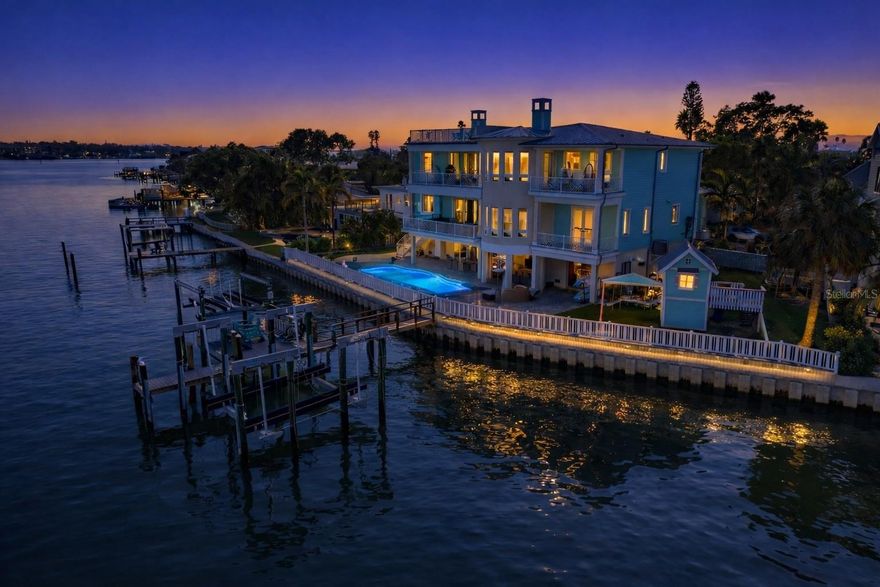 Discover unparalleled waterfront living in this magnificent 6-bedroom, 6.5-bath residence, perfectly situated on a rare double waterfront lot in Indian Rocks Beach. Offering approximately 146 feet of water frontage, an extra-large seawall, private dock, and boat lift, this home is a boater’s dream and an entertainer’s paradise.
Step inside to experience seamless open-concept living designed for both grand entertaining and comfortable everyday life. The chef’s gourmet kitchen features a massive island, high-end professional appliances, and a walk-in pantry, creating a space that is as functional as it is stunning. Impact-rated windows and doors, solid block construction, and a metal roof provide peace of mind and enduring quality.
Resort-style amenities await outdoors, including a Freestyle PebbleTec saltwater pool and a fully equipped outdoor kitchen, ideal for alfresco dining and waterfront gatherings. An elevator offers effortless access to all levels, while a whole-house audio system, smart home technology, and generator ensure comfort, convenience, and security.
The primary suite is a true retreat, featuring a fireplace, private sitting area, expansive walk-in closet accented by a Swarovski chandelier, and a spa-inspired en-suite bath with soaking tub, oversized shower, and private balcony. With seven covered balconies, en-suite baths for every bedroom, two laundry rooms, a dedicated office, and a 3+ car garage, every detail has been thoughtfully designed to elevate the waterfront lifestyle.
This extraordinary home offers a rare opportunity to enjoy luxury, space, and waterfront adventure in one of the area’s most desirable beach communities. Schedule your private showing today and experience coastal living at its finest. Buyer to verify all room sizes and dimensions are approximate.
