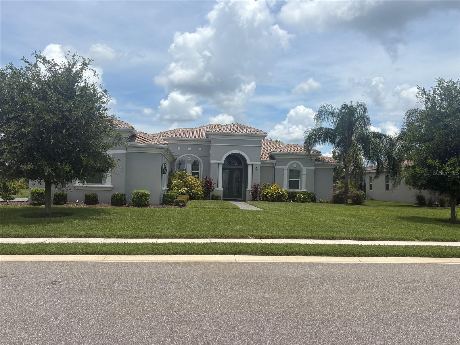 Welcome to 16617 5th Ave E, Bradenton — a beautifully maintained and thoughtfully upgraded home that perfectly blends Florida charm with luxurious comfort. Located in the highly sought-after community of Rye Wilderness Estates, this meticulously cared-for residence offers not only serene water views and a peaceful fountain but also a host of custom enhancements that set it apart from the rest. From the moment you arrive, you'll be captivated by the home's inviting curb appeal, manicured landscaping, and wide paver driveway. Step inside and experience an open, airy layout bathed in natural light with volume ceilings, elegant finishes, and a sense of spacious tranquility. The heart of the home is the expansive great room and kitchen area — ideal for both entertaining and everyday living. The kitchen features granite countertops, stainless steel appliances, a walk-in pantry, 42" cabinets, and a large island with seating. Just beyond, the dining area and living space open seamlessly to the outdoor oasis through sliding glass doors, framing picturesque views of the tranquil pond and its gently bubbling fountain. One of the most impressive features of this home is the custom outdoor kitchen and entertainment area, added by the current owners to enhance Florida's year-round outdoor living lifestyle. Fully equipped with a built-in grill, prep sink, refrigerator, and generous counter space, this space is perfect for hosting gatherings or enjoying a quiet evening meal. The lanai has been upgraded with soft, integrated lighting to create an ambient glow in the evenings, making the outdoor space as comfortable and welcoming as the indoors. Another standout improvement is the enclosed flex space, originally a den or formal living area, now thoughtfully transformed into a light-filled home office with the addition of custom glass French doors. This versatile room enjoys plenty of sunshine and offers privacy without sacrificing connection to the rest of the home, making it ideal for remote work, reading, or creative pursuits. The primary suite is a serene retreat, complete with water views, dual walk-in closets, and a spacious en-suite bath featuring dual vanities, a soaking tub, and a walk-in shower. The split floor plan offers privacy, with secondary bedrooms situated on the opposite side of the home, each generous in size and comfort. Step outside and enjoy the fully screened lanai, where your eyes are immediately drawn to the shimmering water and the soothing sound of the fountain — a perfect backdrop for morning coffee or evening relaxation. The backyard offers ample room for a pool, garden, or play area, with unobstructed views and a true sense of openness. Additional highlights include a three-car garage, tile roof, energy-efficient systems, and hurricane shutters for peace of mind. This home is not just move-in ready — it's lifestyle-ready. Conveniently located near top-rated schools, shopping, dining, and just a short drive to Lakewood Ranch, I-75, and the beautiful Gulf beaches, 16617 5th Ave E offers the rare combination of elegance, functionality, and Florida living at its finest. Don’t miss your chance to own this exceptional property — where every upgrade was made with care and quality in mind. Schedule your private showing today!