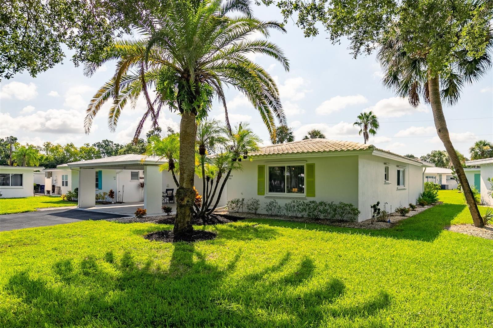 Welcome to this beautifully maintained 2-bedroom, 2-bath villa in the desirable 55+ maintenance-free community of Strathmore Villas. This home offers privacy with no shared living walls—only the carport and storage area are attached with neighbor. The open floor plan is filled with natural light and flows seamlessly to a spacious green space with a paver patio, perfect for relaxing or entertaining. A detached laundry/utility room provides washer, dryer, cabinets, water heater, and hurricane panels for the windows. Recent updates include newer windows and fresh interior/exterior paint. Extra-long driveway for additional parking. The monthly HOA fee covers cable TV, water, sewer, exterior maintenance (including roofs), lawn irrigation, clubhouse, heated pool, and on-site staff. Strathmore Villas offers a vibrant lifestyle, conveniently located near downtown Sarasota, Bayfront Park, St. Armands Circle, UTC Mall, Benderson Park, dining, shopping, and world-class beaches. Don’t miss this opportunity—schedule your private showing today!
